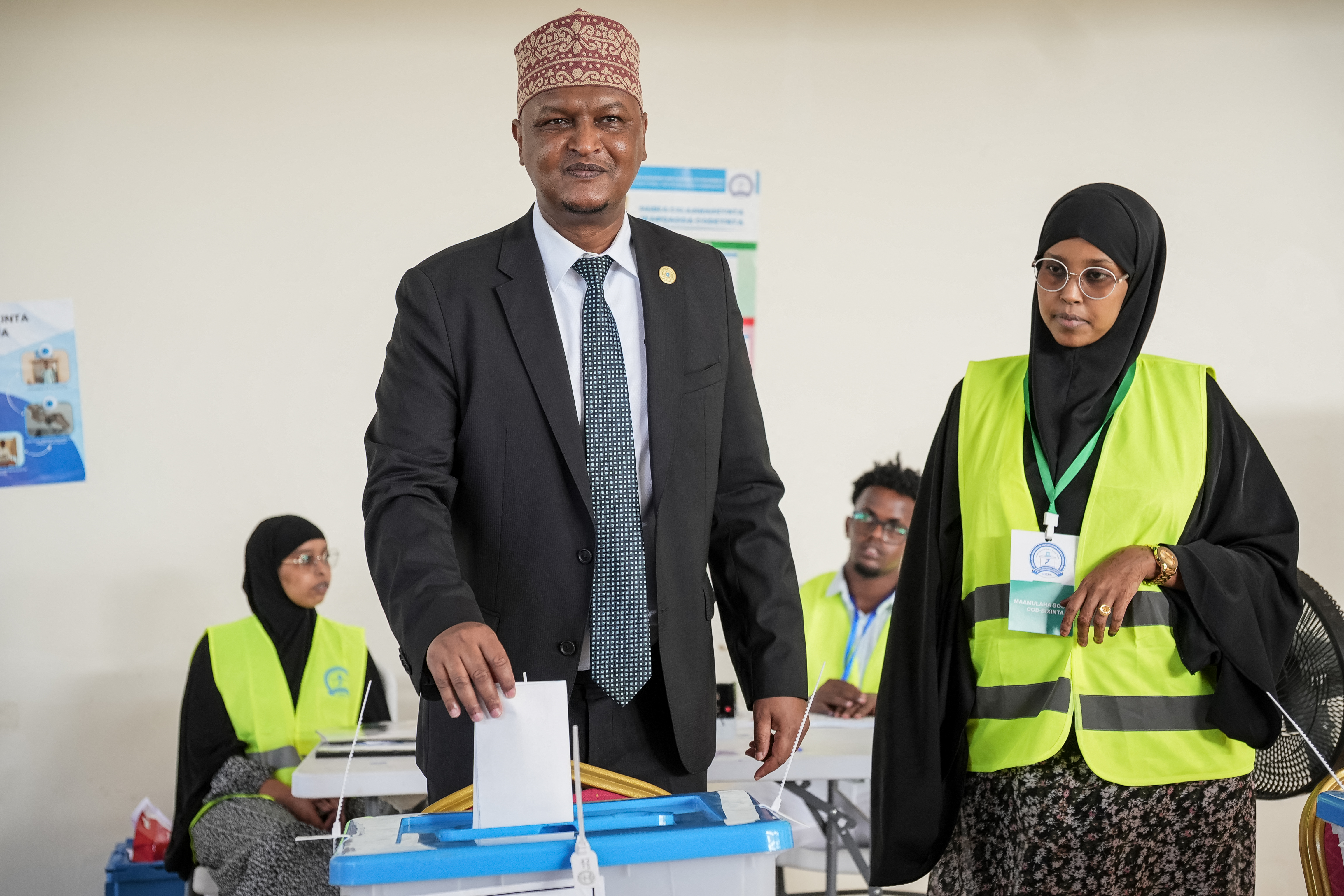 A voter casts his ballot paper at a polling station during local council elections in Mogadishu on December 25, 2025. Somalia's capital, Mogadishu, heads to the polls on December 25, 2025 for local elections, the first time in 58 years, under a complete citywide lockdown amid security concerns. (Photo by Hassan Ali ELMI / AFP)