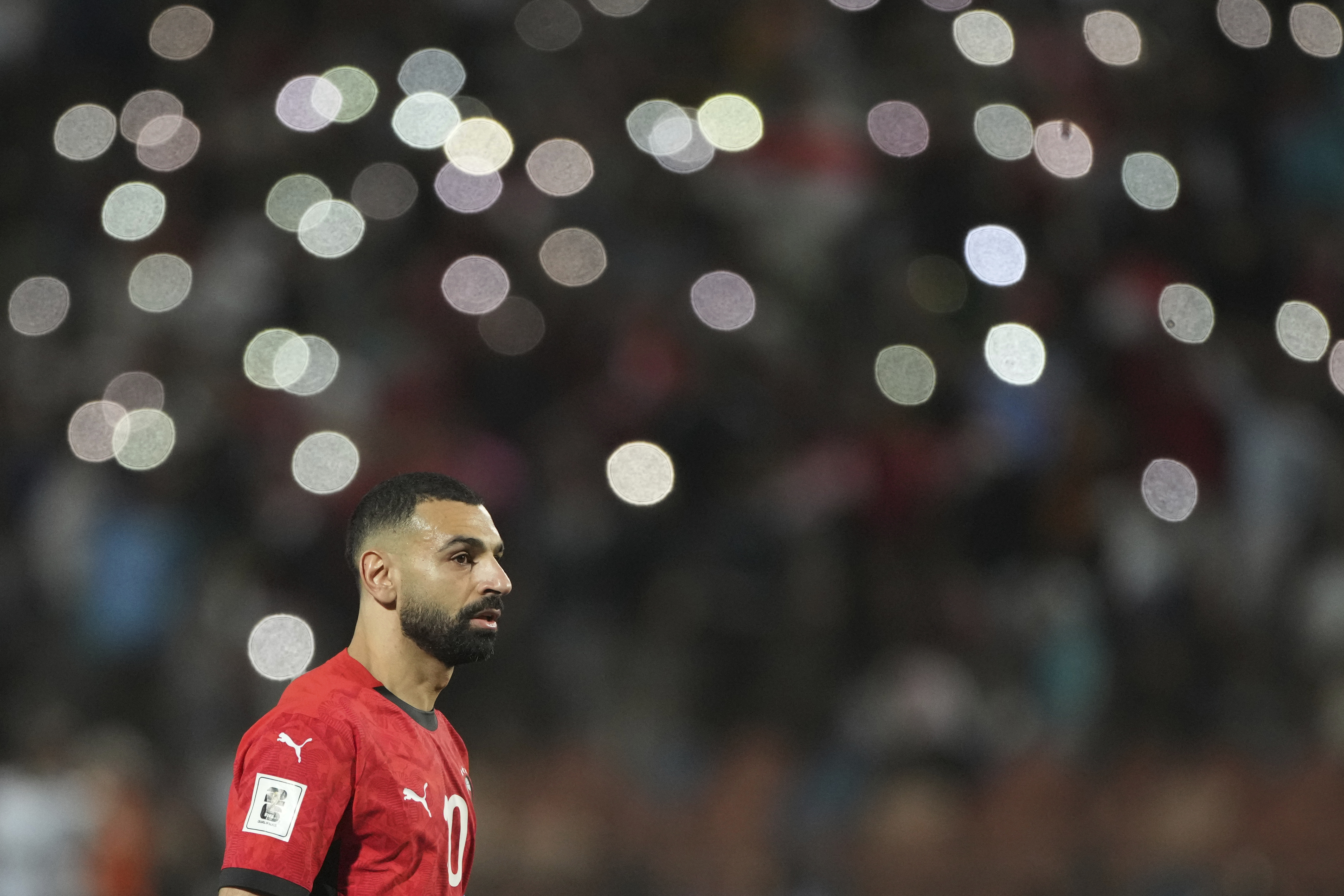 Fans spot lights surround Egypt's Mohamed Salah during a World Cup 2026 qualifying soccer match between Egypt and Sierra Leone at Cairo International Stadium, Egypt, Tuesday, March 25, 2025. (AP Photo/Amr Nabil)