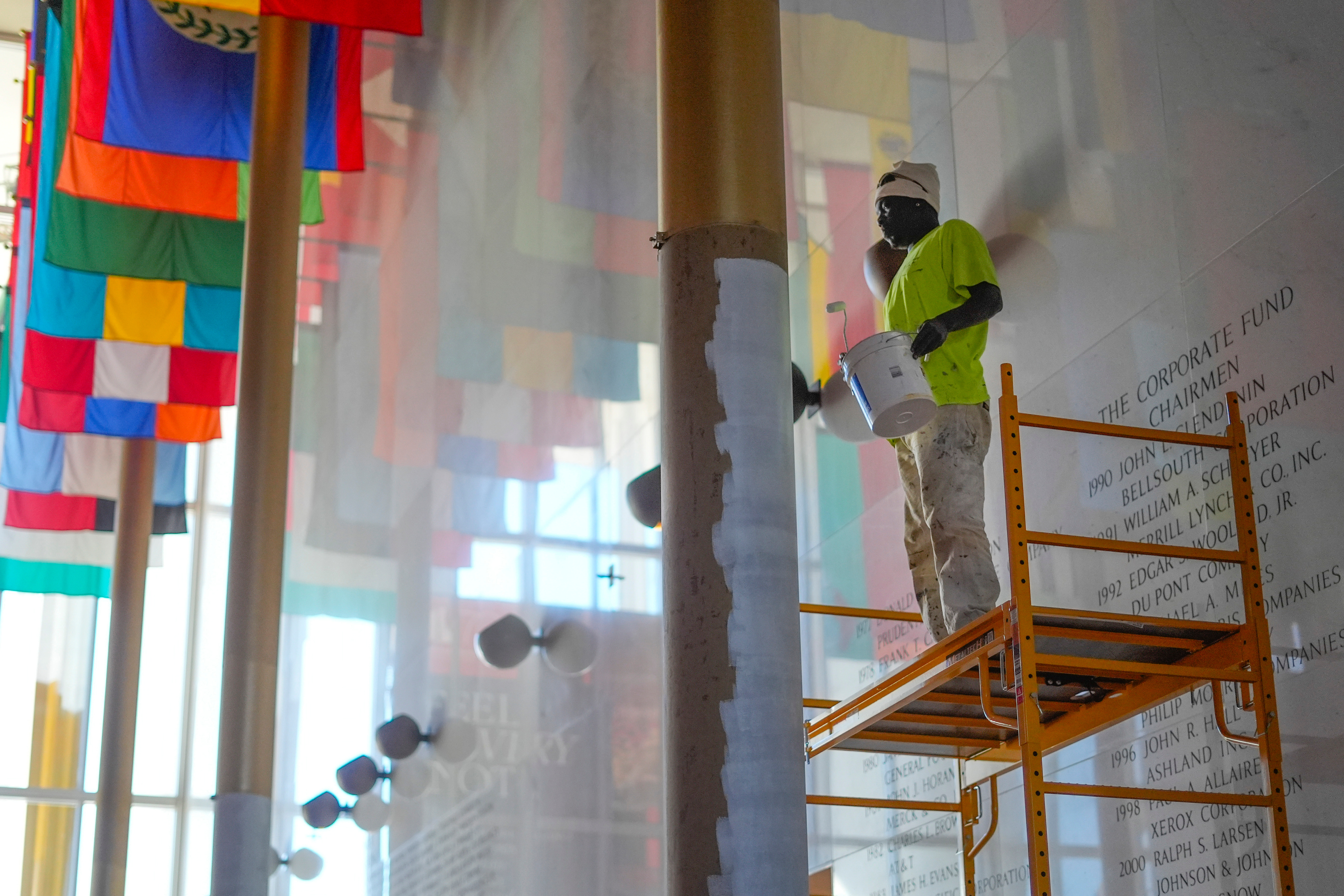 Worker paints gold columns white at the Kennedy Center