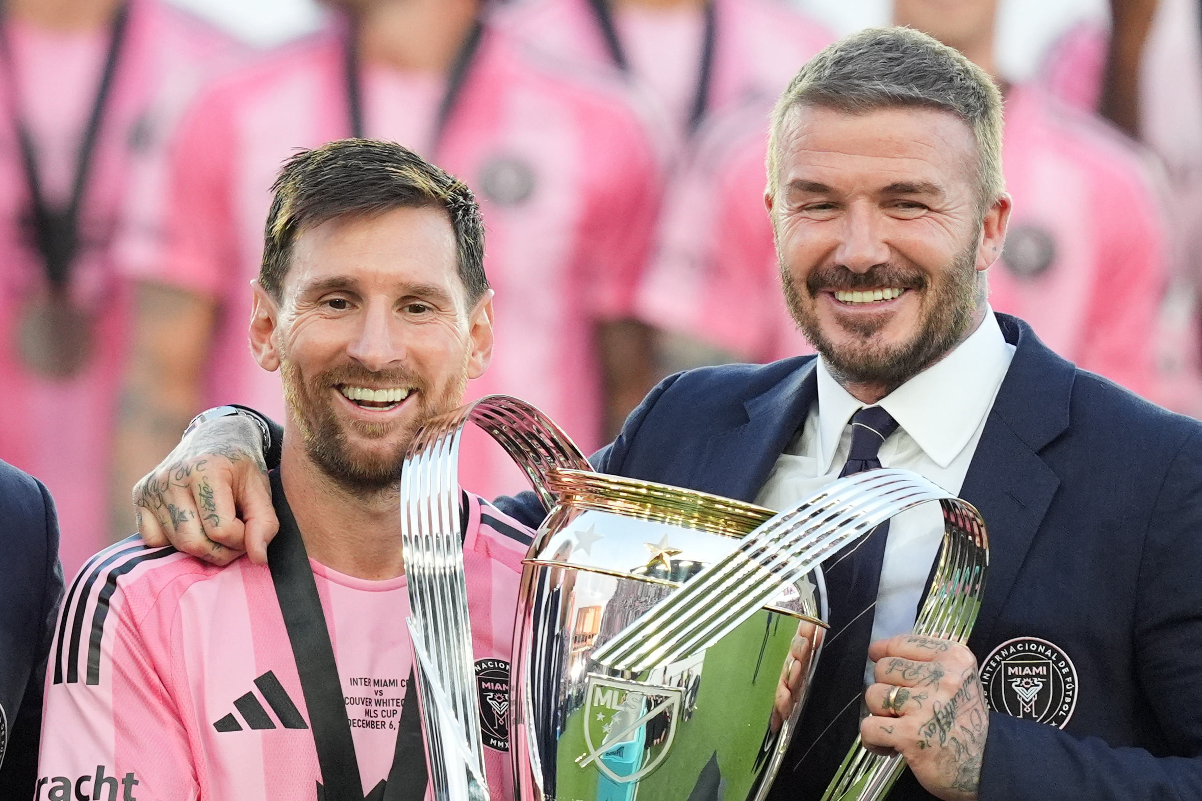 Lionel Messi and David Beckham pose with the trophy.