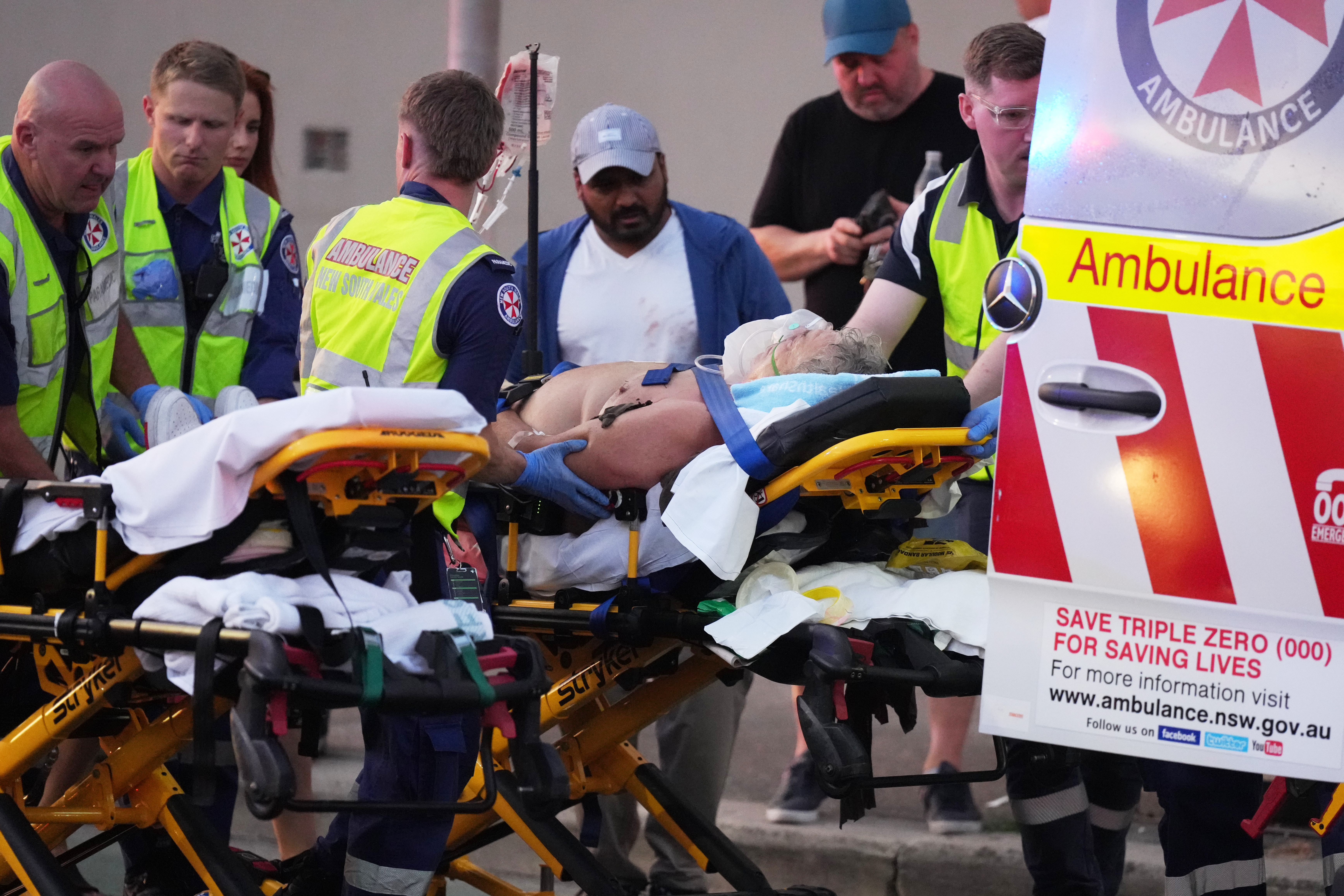 Emergency workers transport a person on a stretcher after a reported shooting at Bondi Beach in Sydney