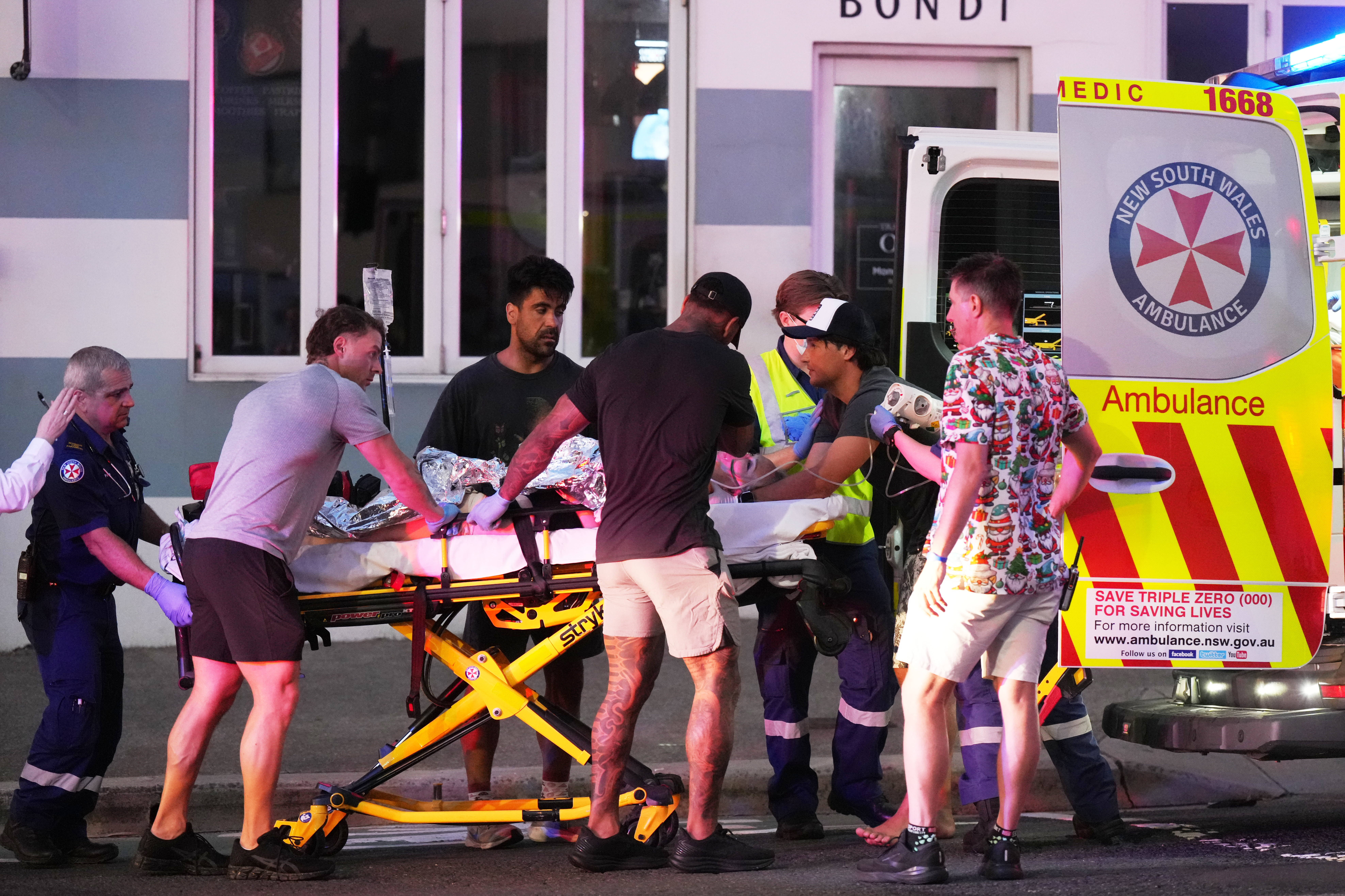 Emergency workers carry a person on a stretcher after a reported shooting at Bondi Beach in Sydney