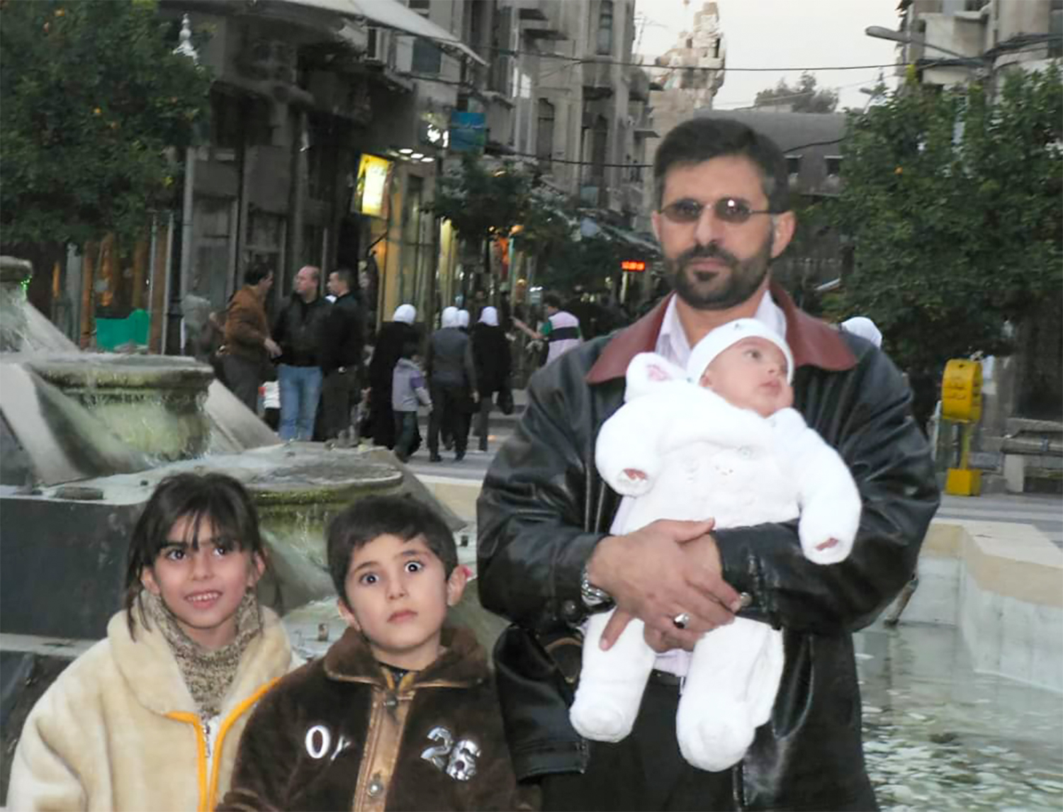 Fouziah on the left, Omar (middle) and baby Ahmed being held by his father Mohammed in Damascus.