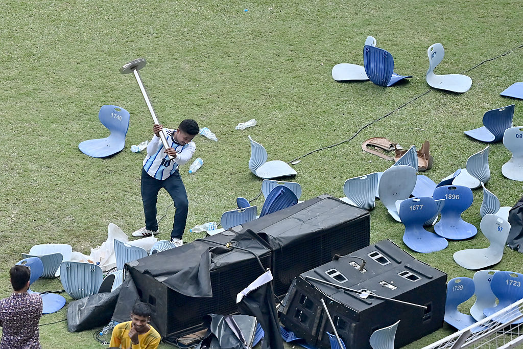 A fan hits a sound system with a pole during the Lionel Messi G.O.A.T Tour