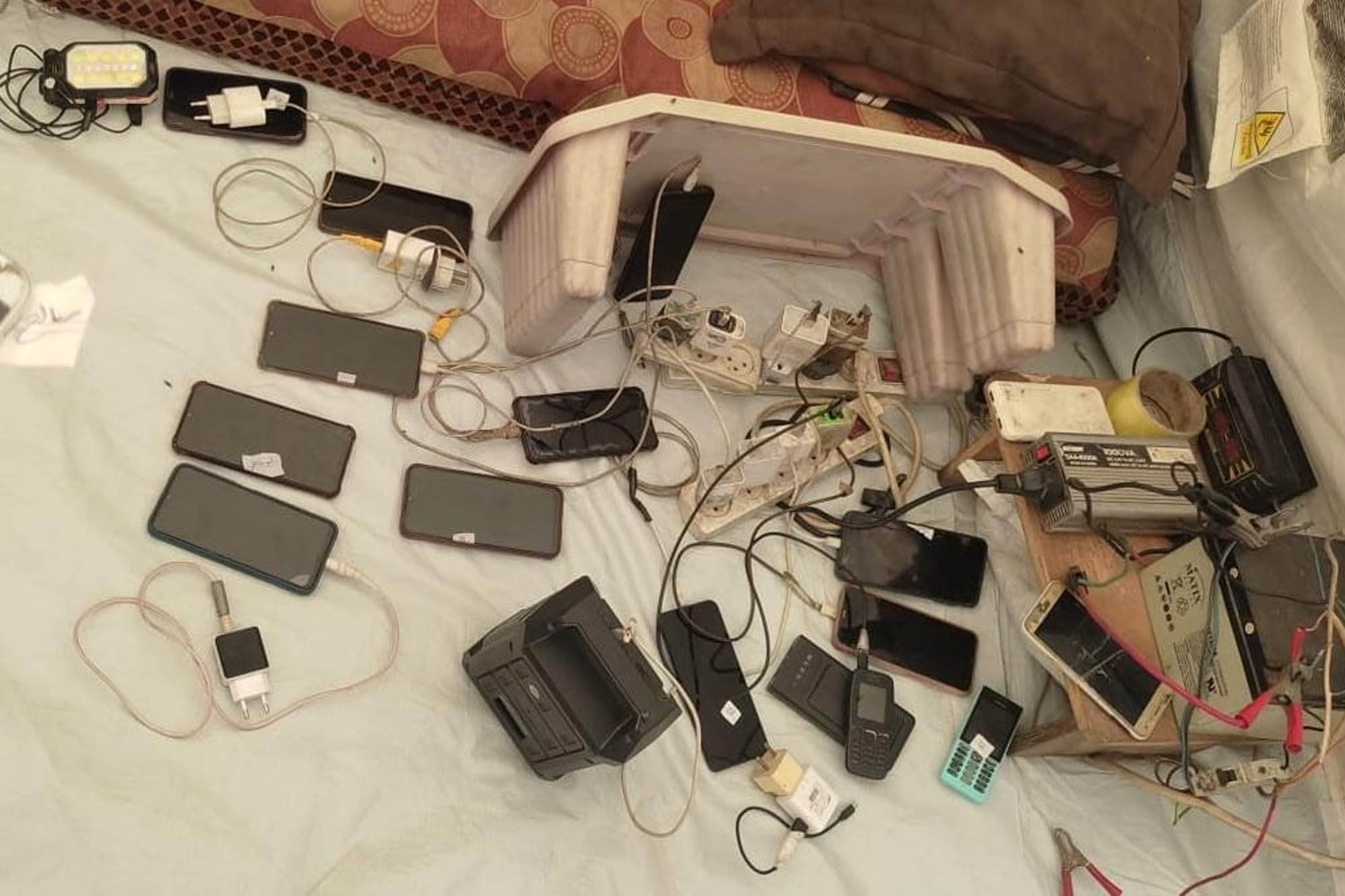 a photo of a dozen phones charging