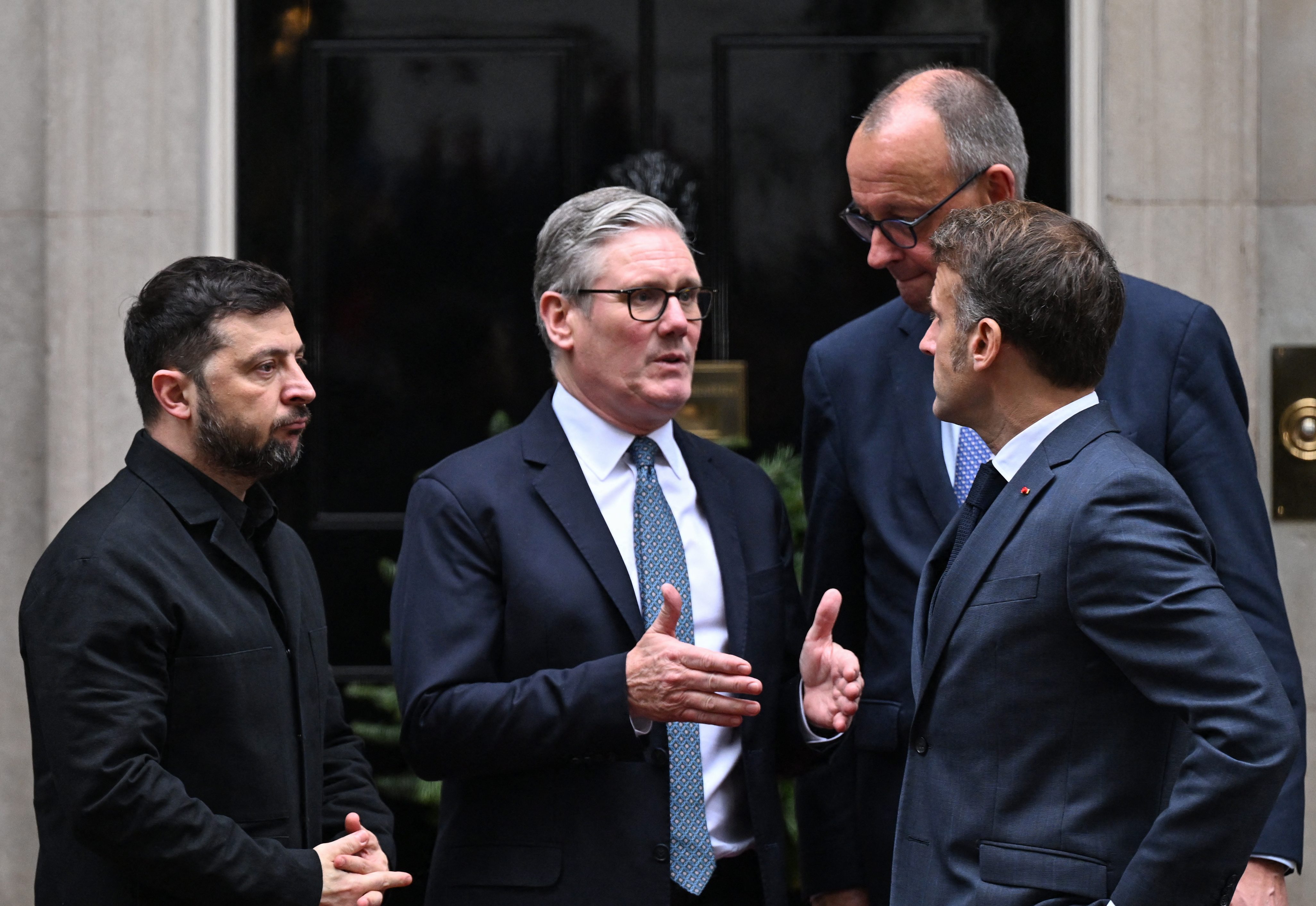 Ukraine's President Volodymyr Zelensky (L), Britain's Prime Minister Keir Starmer (2nd L), French President Emmanuel Macron (front R) and Germany's Chancellor Friedrich Merz (back R) chat outside Number 10 Downing Street following their talks in central London on December 8, 2025. (Photo by Chris J Ratcliffe / AFP)