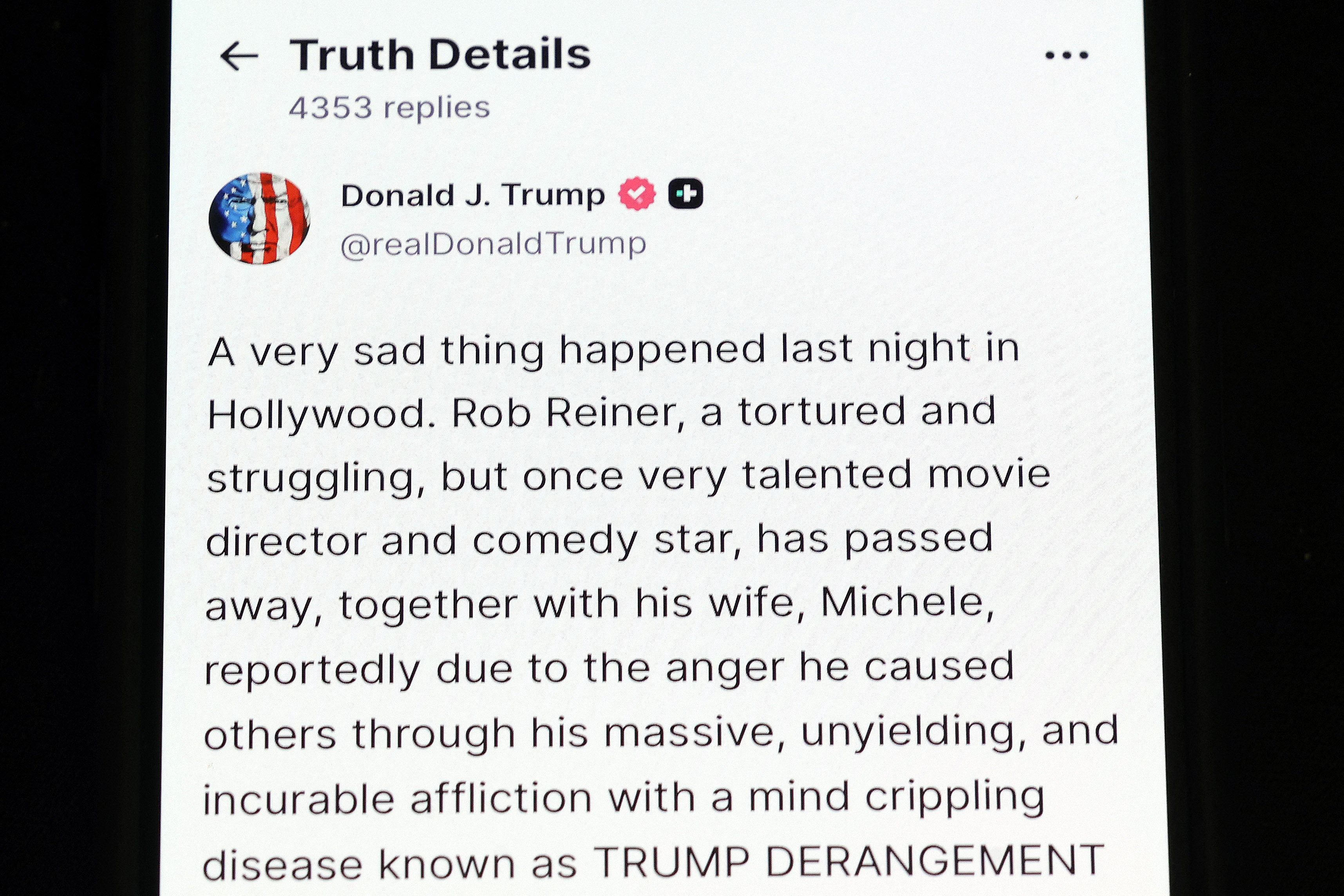 WASHINGTON, DC - DECEMBER 15: In this photo illustration, a phone shows U.S. President Donald Trump's Truth Social post on the death of actor and director Rob Reiner on December 15, 2025 in Washington, DC. Reiner and his wife, Michele Singer Reiner, were found dead in their Brentwood home on December 14th. (Photo illustration by Kevin Dietsch/Getty Images) (Photo by Kevin Dietsch / GETTY IMAGES NORTH AMERICA / Getty Images via AFP)