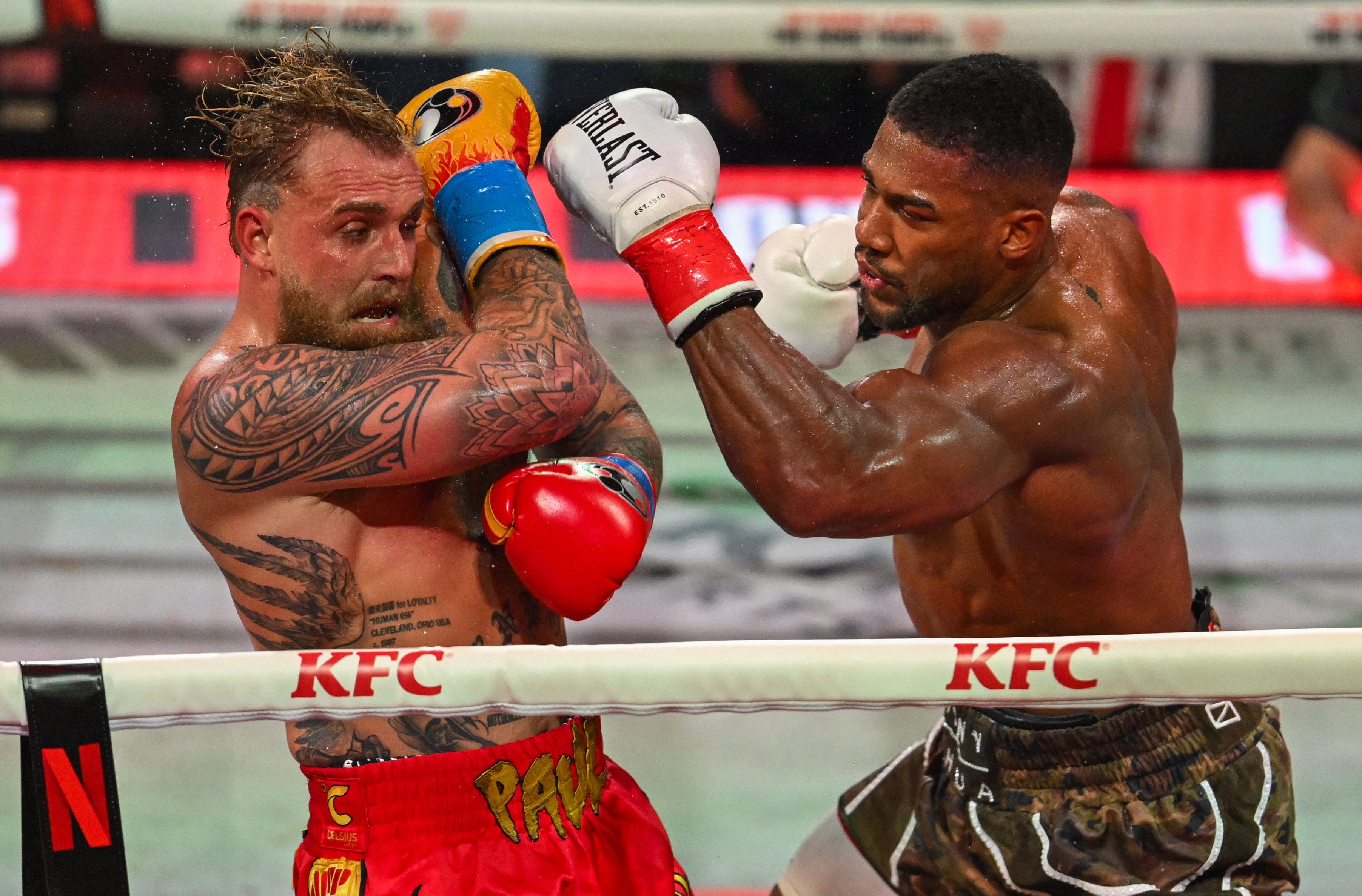 US boxer and influencer Jake Paul (L) and British boxer Anthony Joshua fight in a non-title heavyweight bout at the Kaseya Center in Miami, Florida on December 19, 2025.