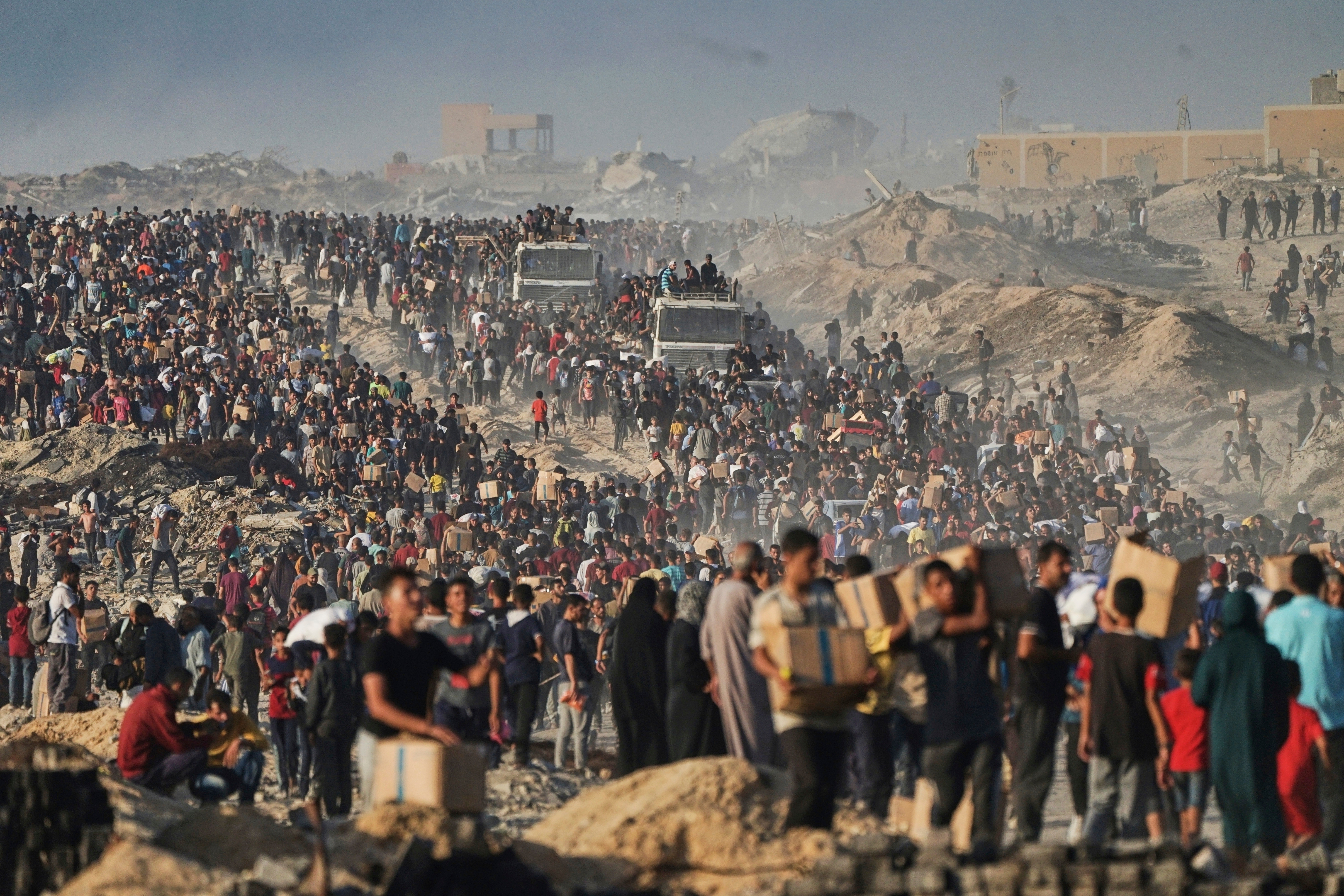 People carry sacks and boxes of food and humanitarian aid.