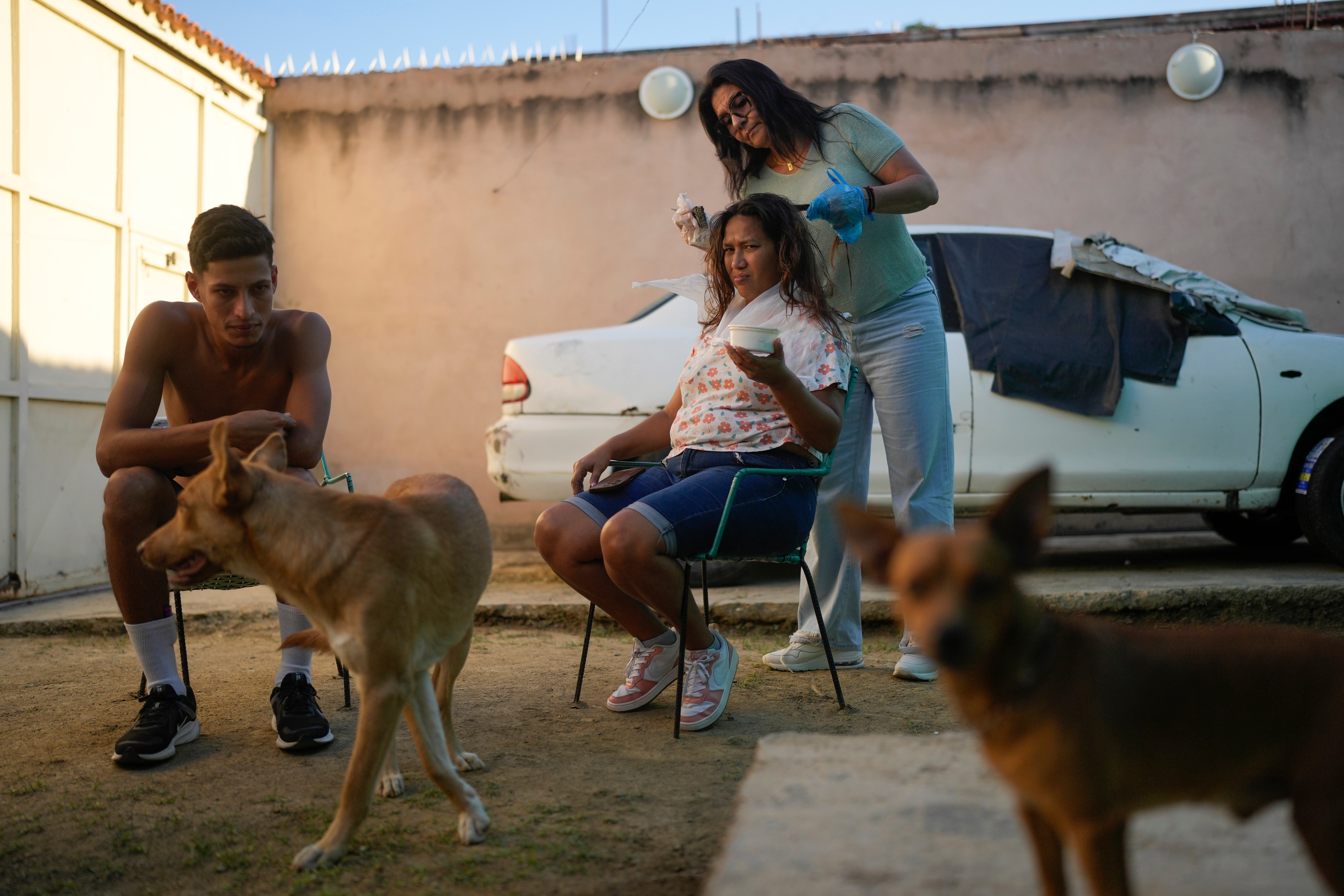 Mariela Gómez, a Venezuelan migrant who abandoned her journey with her children to the United States to return home following President Donald Trump's immigration crackdown, has her hair dyed for Christmas dinner in Maracay, Venezuela, Friday, Dec. 24, 2025. (AP Photo/Matias Delacroix)