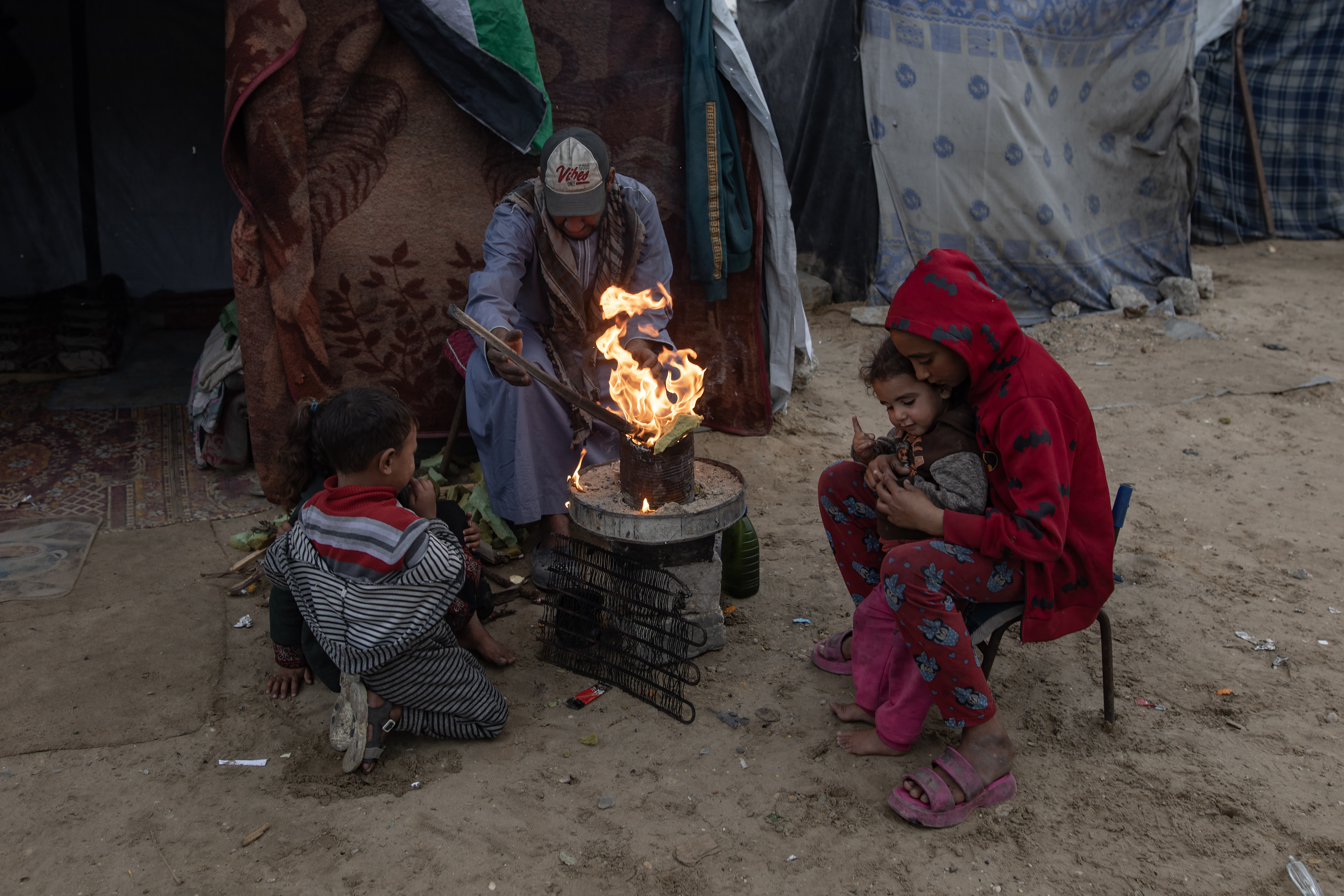 epa12594418 A displaced Palestinian family light a fire for warmth outside their shelter in the city of Khan Younis, in the southern Gaza Strip, 15 December, 2025. According to the UN around 90 percent of the population or 1.9 million people in Gaza have been displaced since the start of the conflict. EPA/HAITHAM IMAD