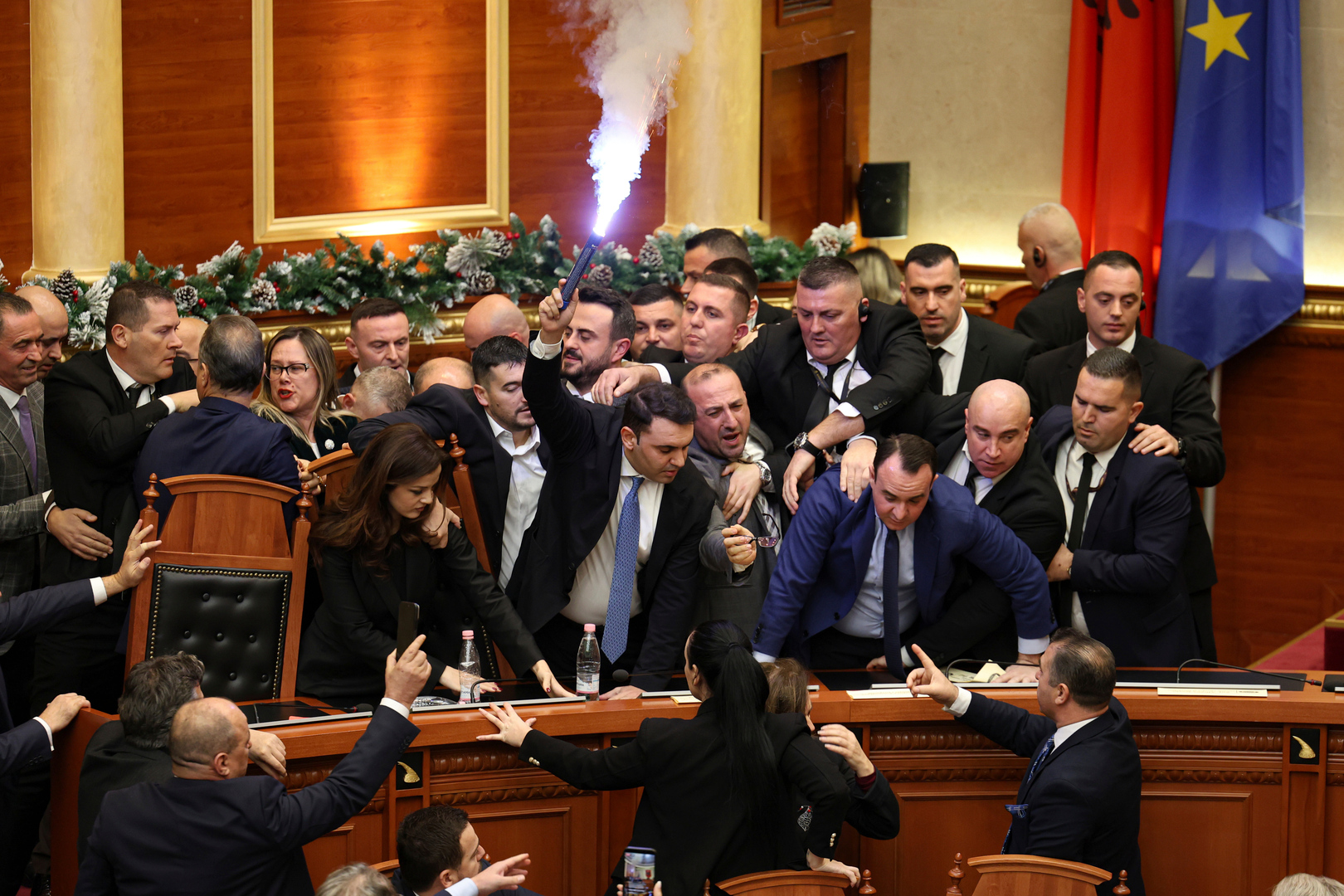 Belind Kellici, a Member of Parliament representing the Democratic Party, holds a flare during tensions between the ruling Socialist Party and the opposition during a parliament session in Tirana, Albania on Dec. 18, 2025. [AP Photo]