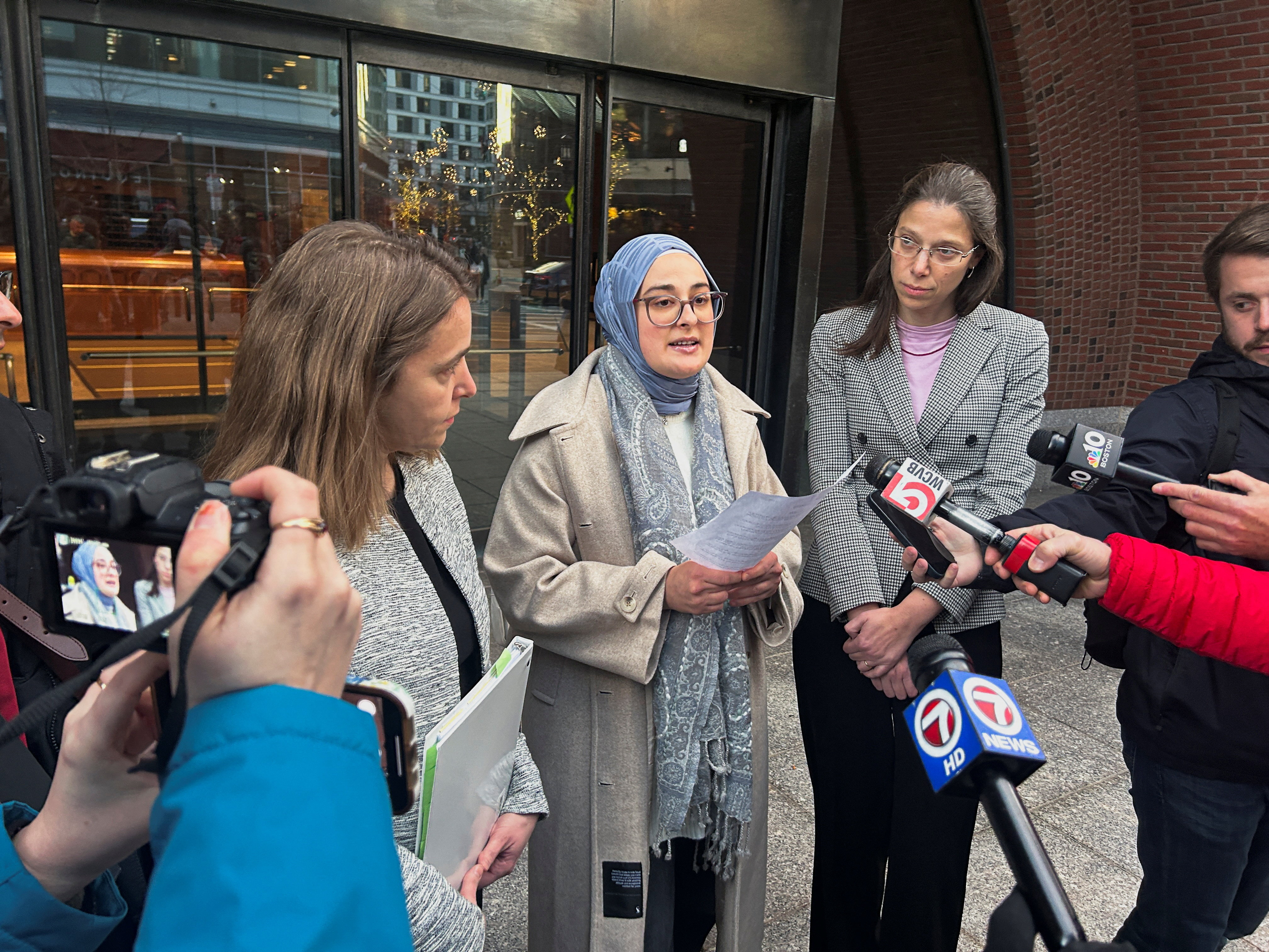 Rumeysa Ozturk speaks to reporters outside a court.