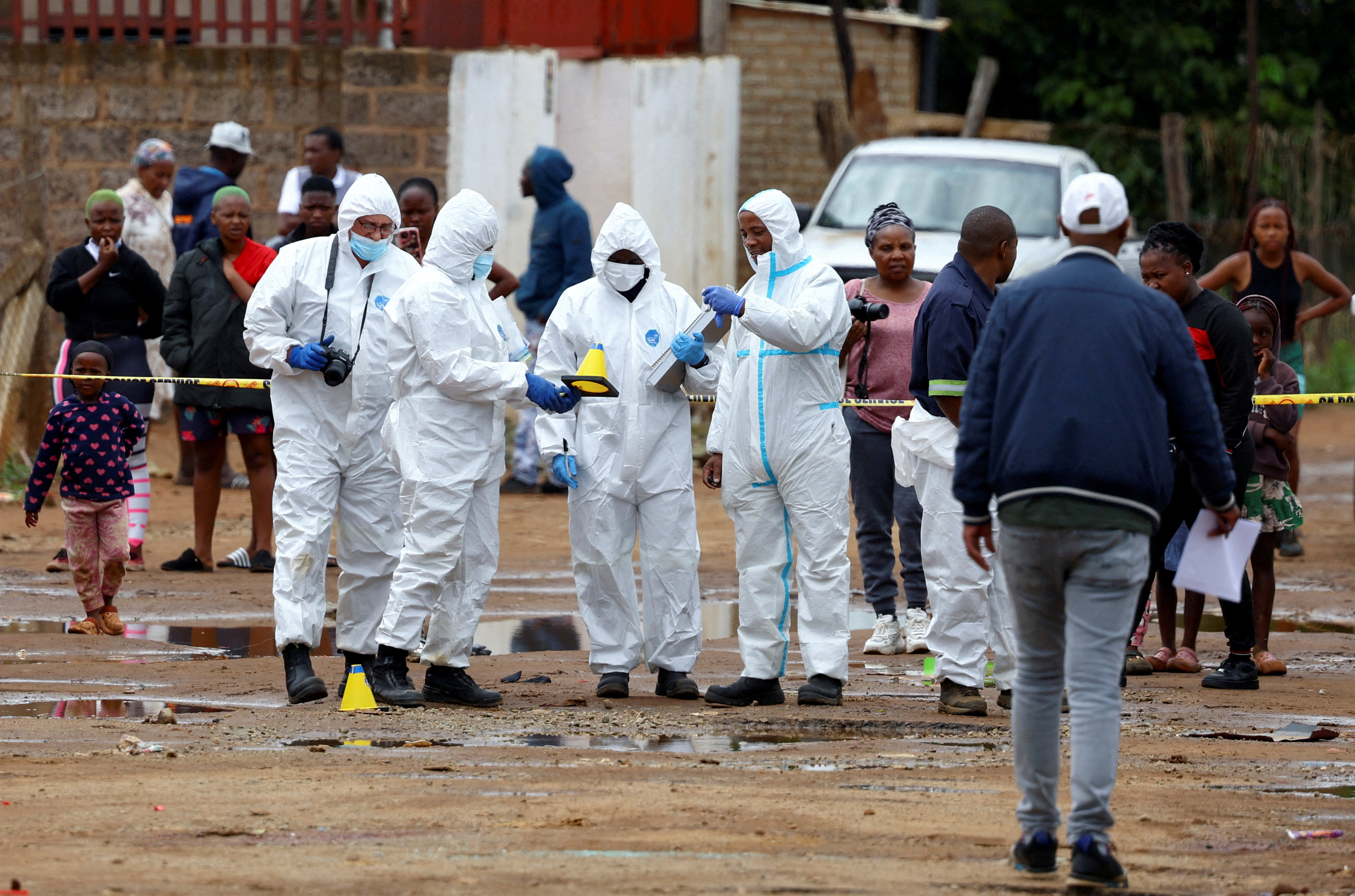 Forensic officials work at the scene of an early morning shooting in Bekkersdal township, south-west of Johannesburg, South Africa December 21, 2025. REUTERS/Siphiwe Sibeko TPX IMAGES OF THE DAY