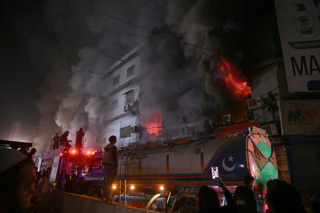 Firefighters douse a fire that broke out at a shopping mall in Karachi on January 18, 2026. (Photo by Rizwan TABASSUM / AFP)