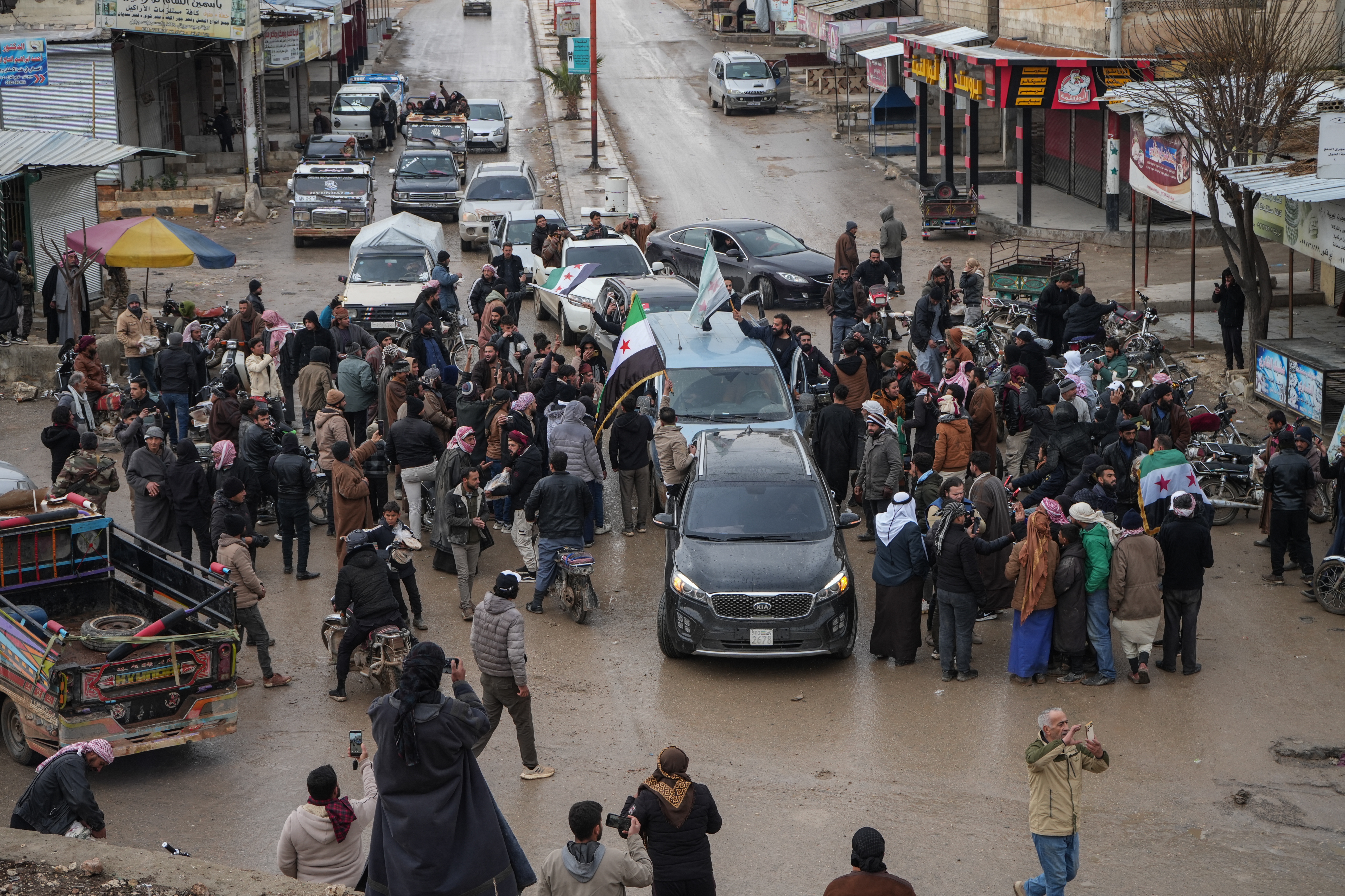People celebrate the entry of Syrian army forces into the Deir Hafer area