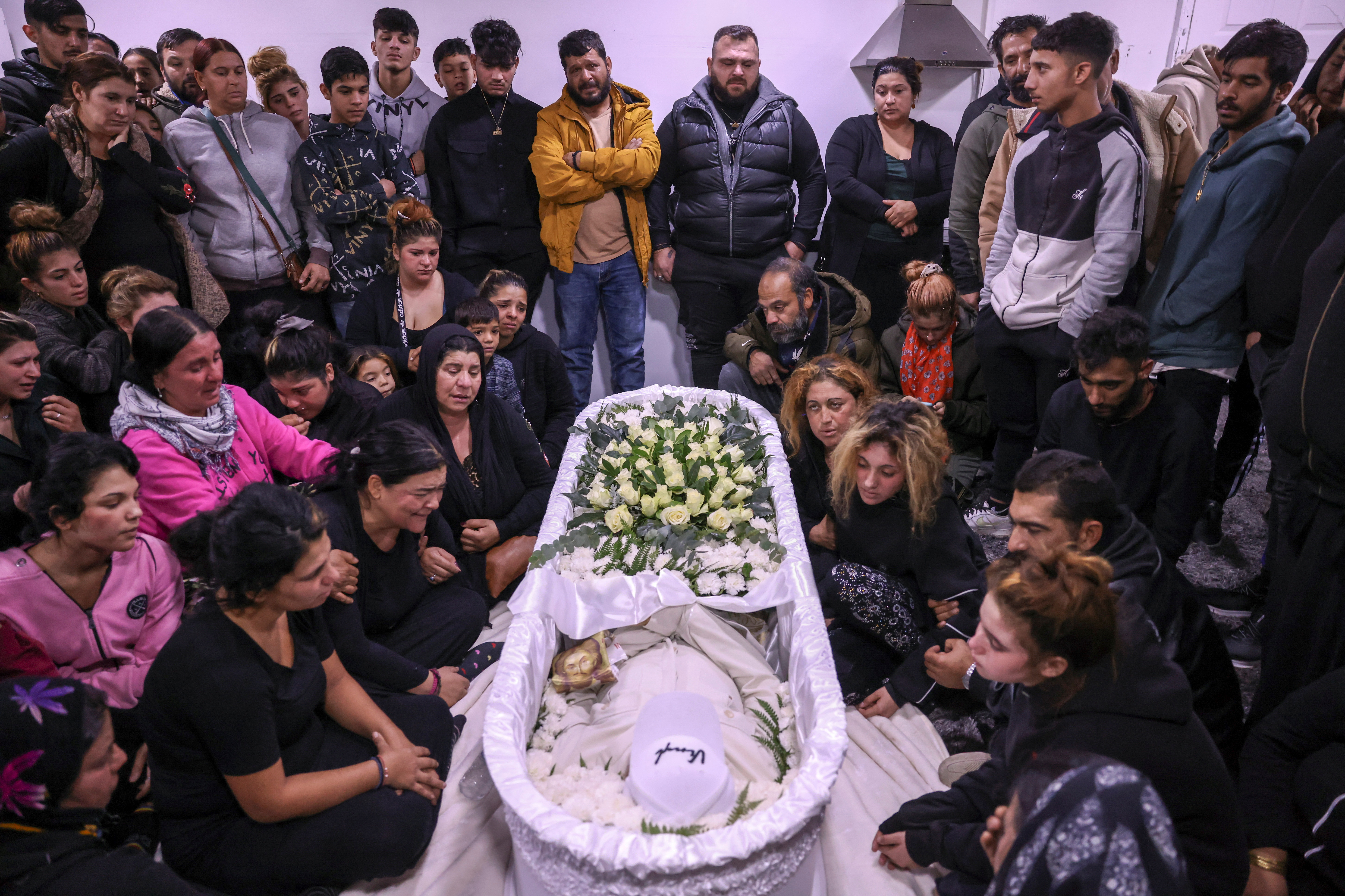 Relatives and friends of 16-year old Roma Costas Fragoulis, who was fatally shot by police, mourn next to his coffin in his house, in Thessaloniki, Greece, December 14, 2022. REUTERS/Alexandros Avramidis