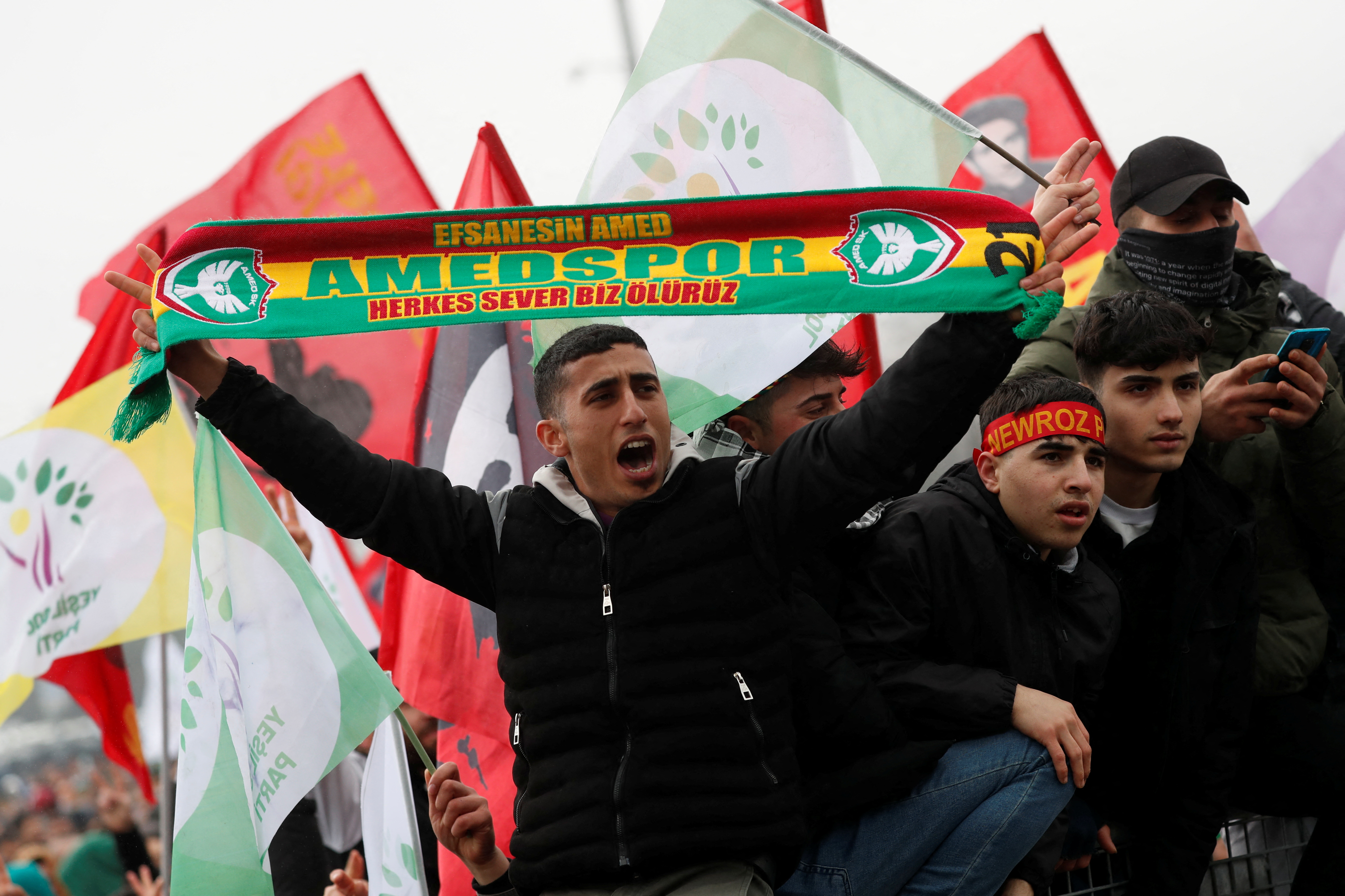 A man shouts slogans as he holds a scarf of Amedspor soccer team