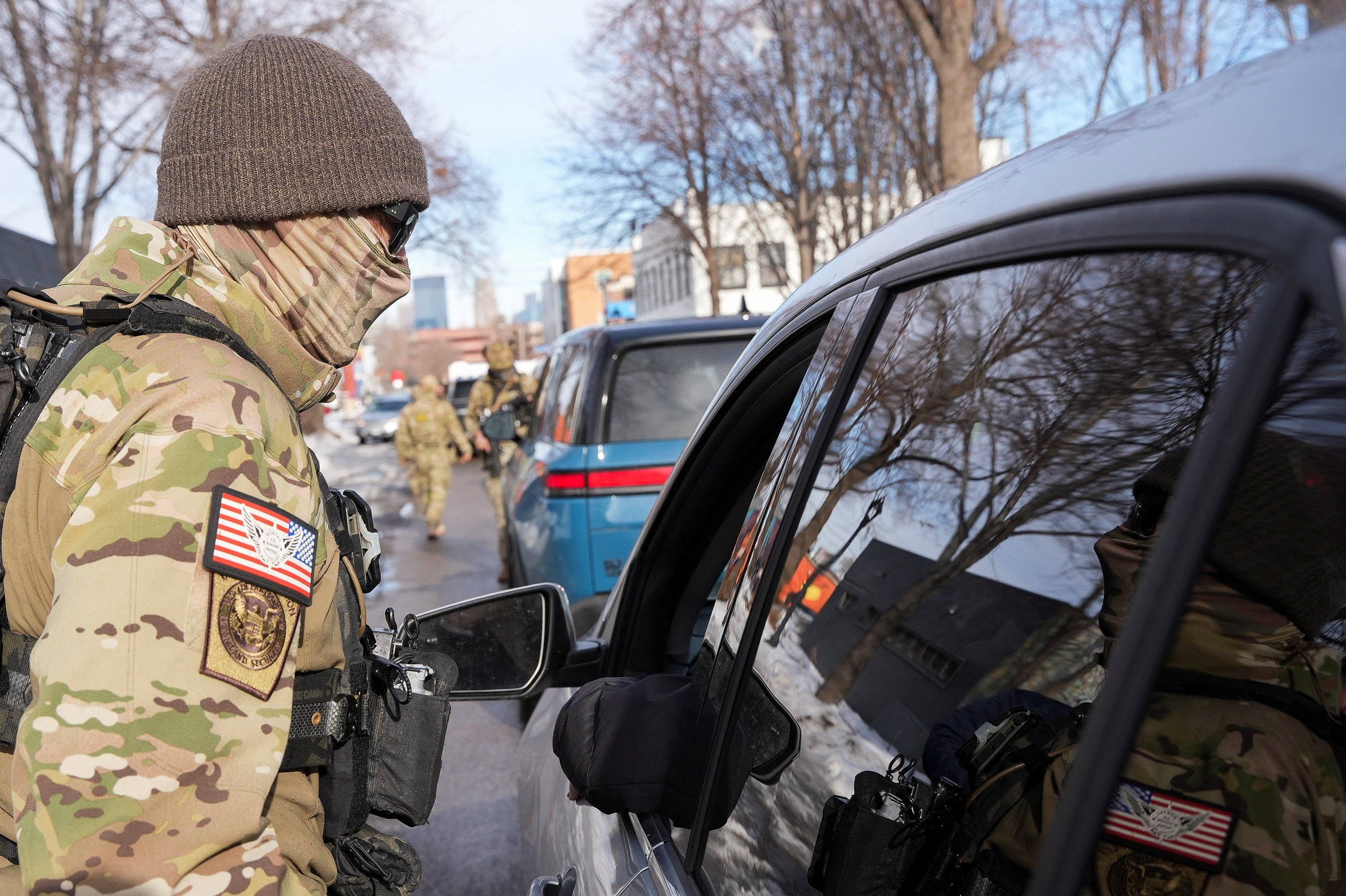 A Border Patrol agent approaches a car