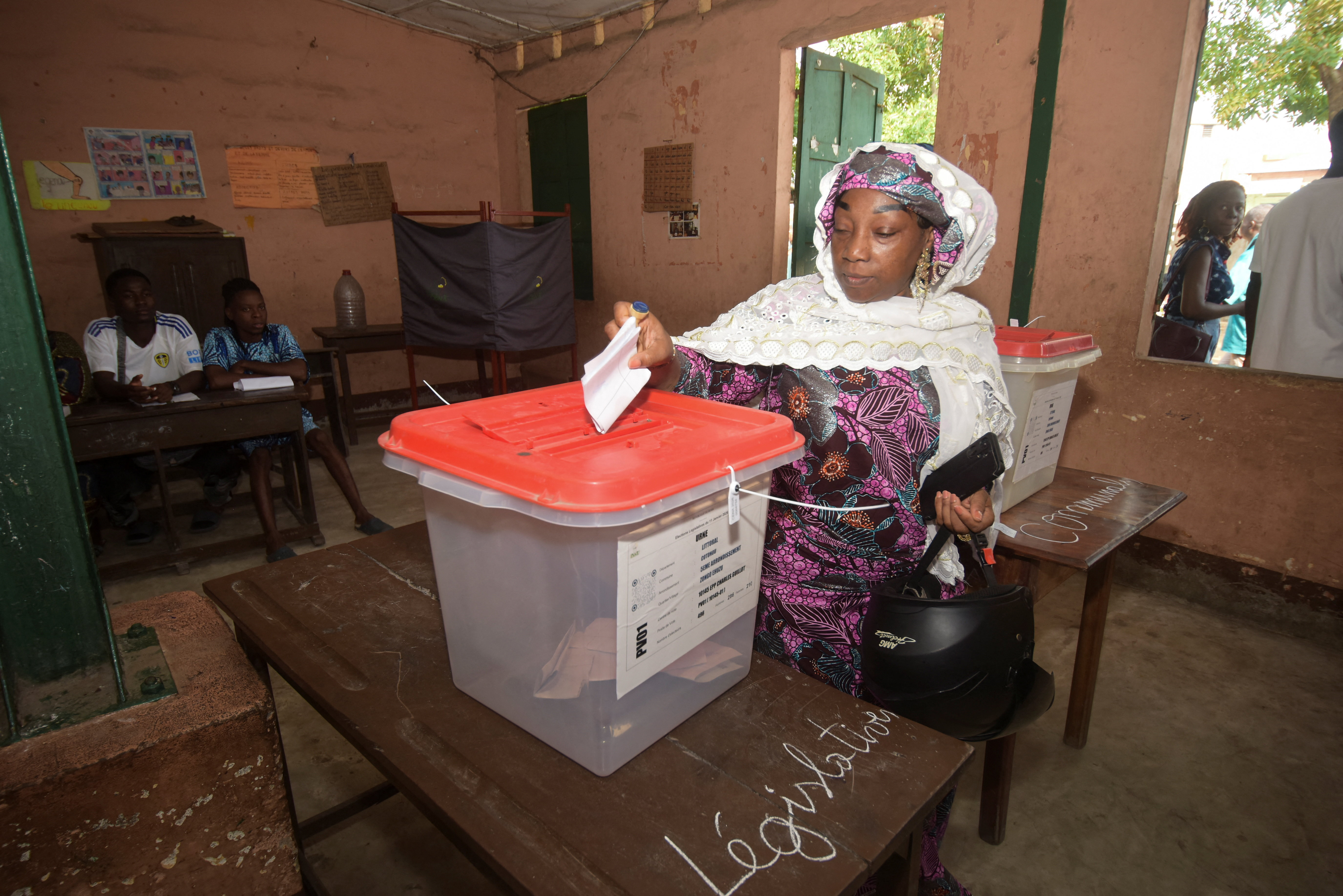A woman casts her vote at a polling station during the parliamentary election, in Cotonou, Benin