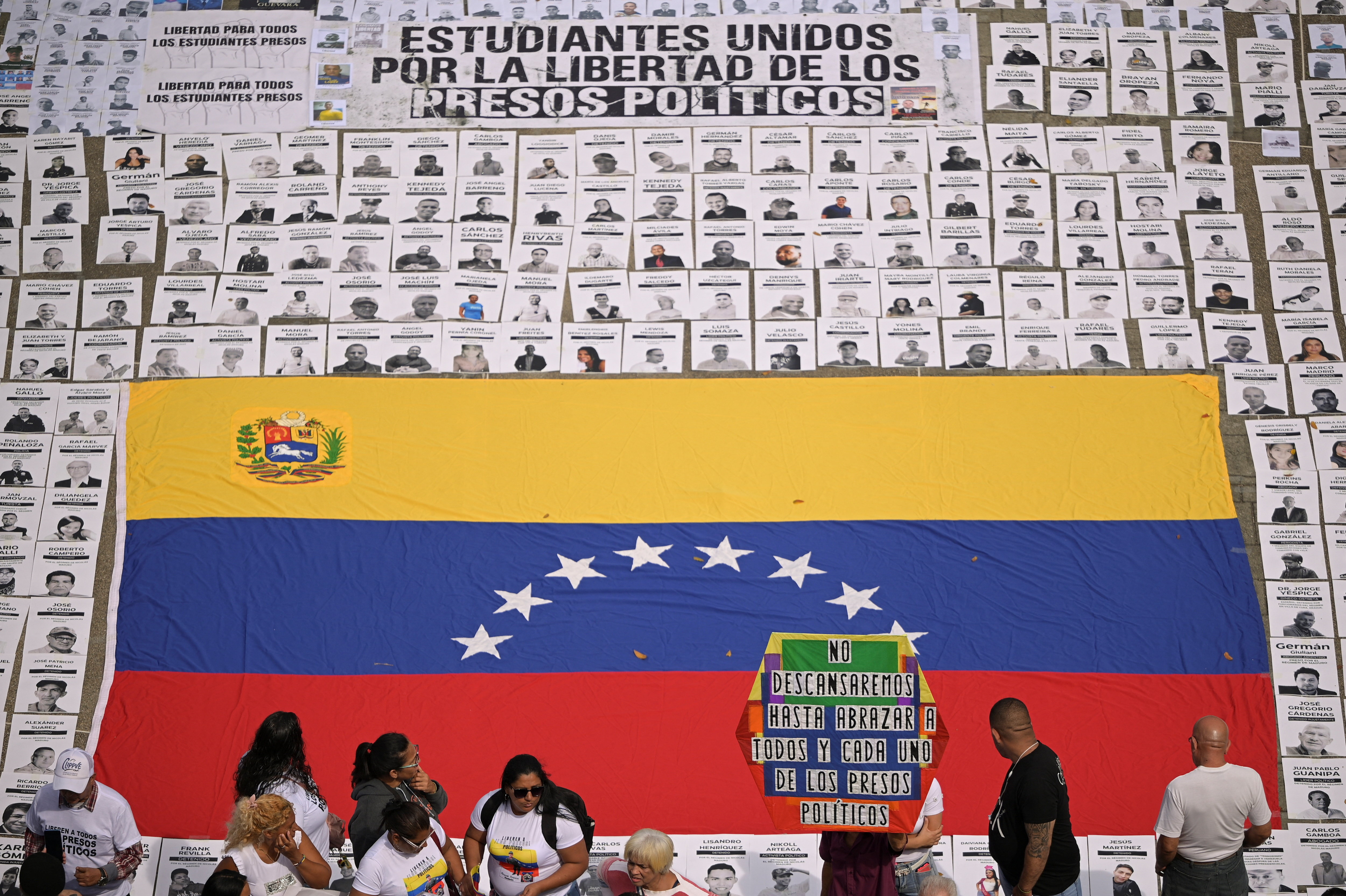 Images of Venezuelan prisoners surrounding a huge Venezuelan flag at a protest calling for prisoners to be released.
