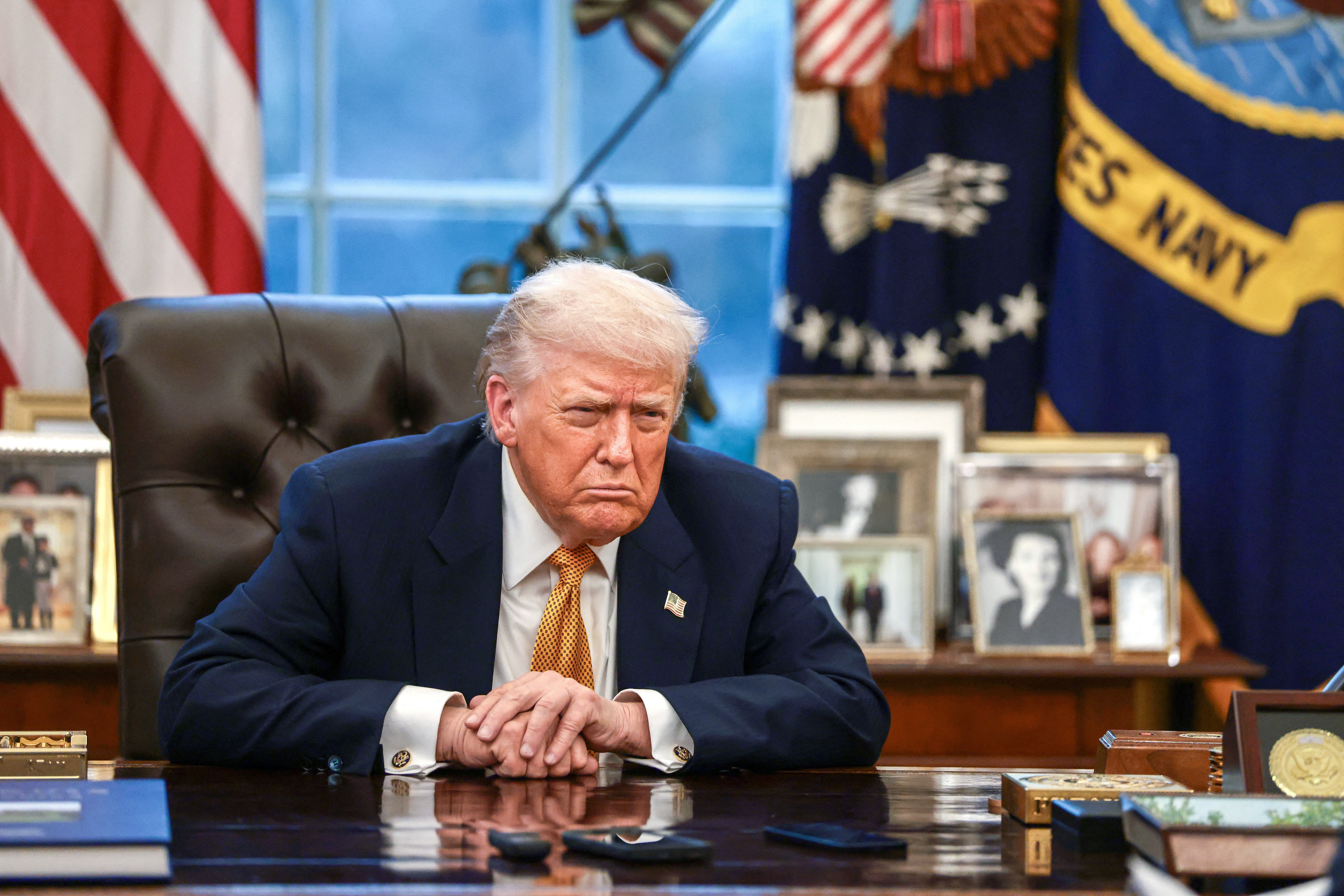 Donald Trump sits as his desk in an interview.
