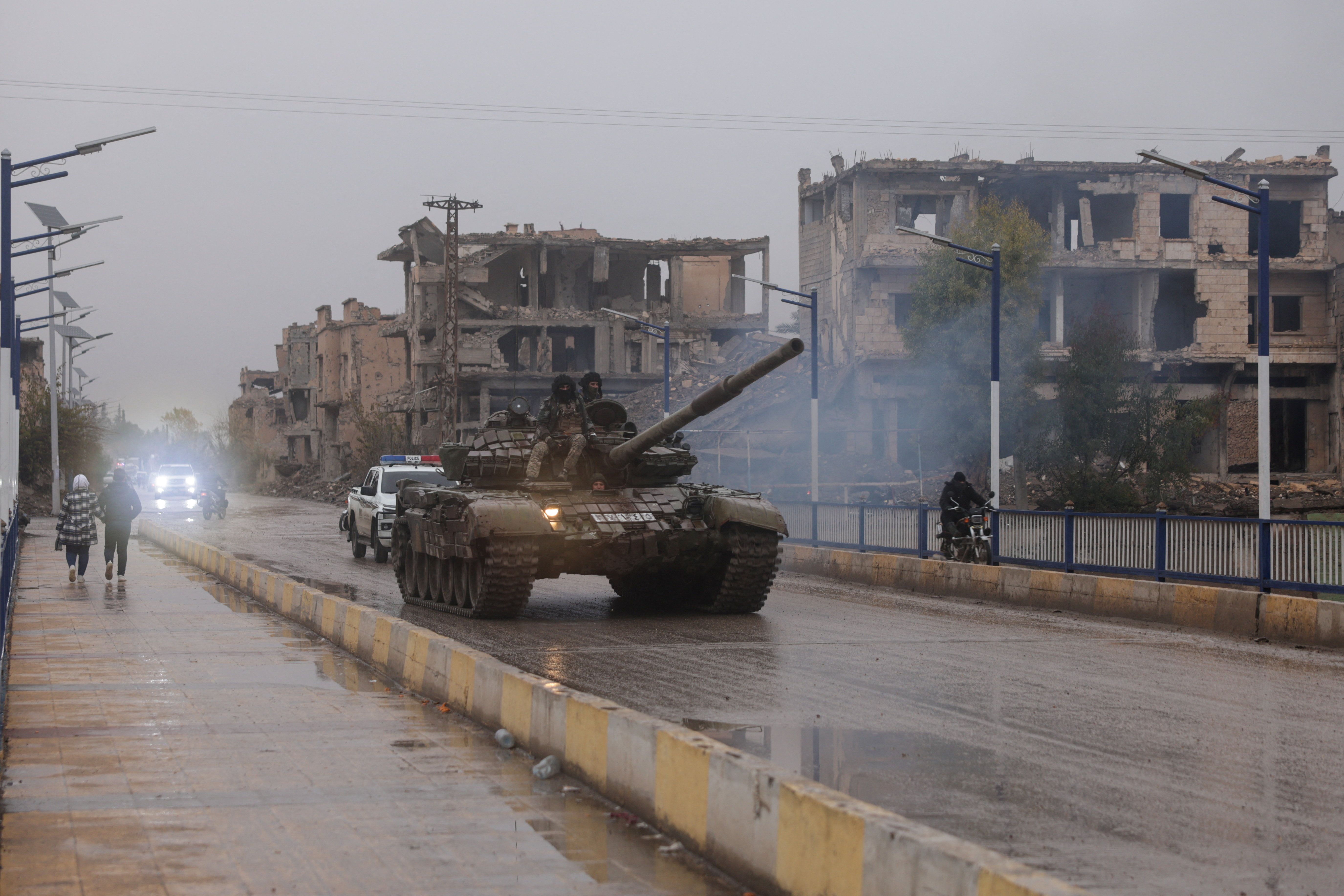 Military personnel sit on top of a tank, after the Syrian Democratic Forces withdrew from Deir Az Zor province