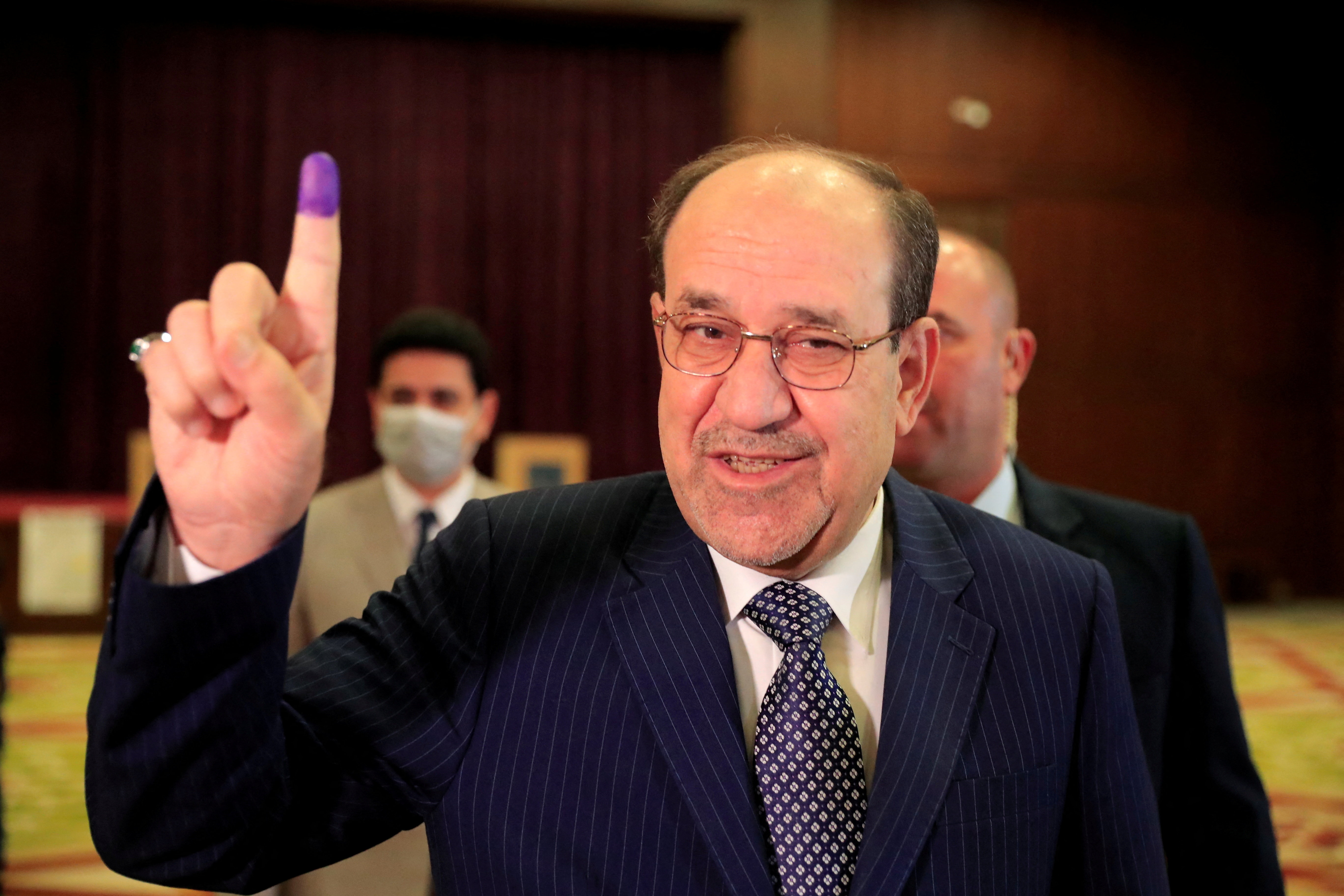 FILE PHOTO: Former Iraqi Prime Minister Nouri al-Maliki shows his inked finger at a polling station in Baghdad, as Iraqis go to the poll to vote in the parliamentary election, in Iraq, October 10, 2021. REUTERS/Thaier al-Sudani/File Photo