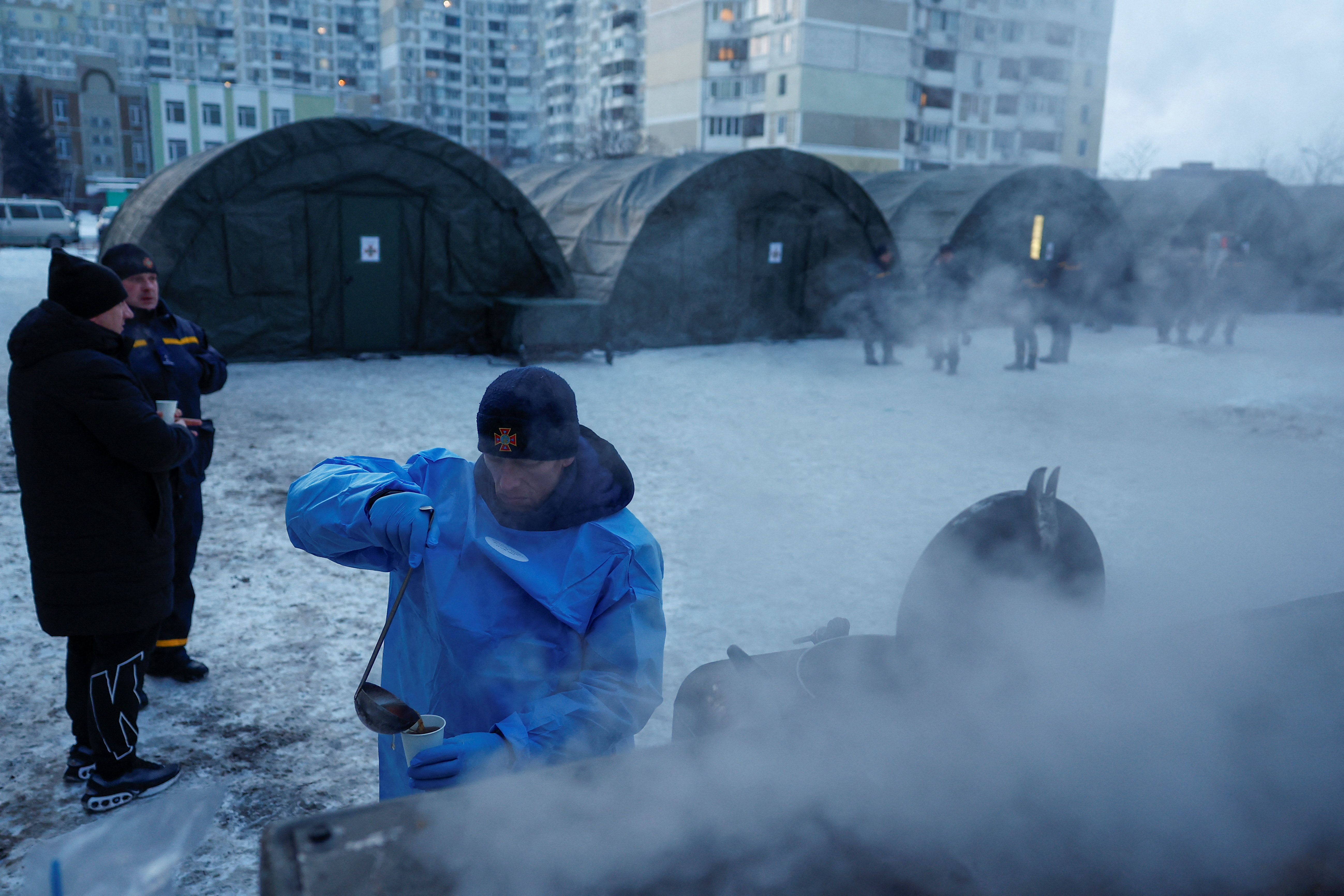 A State Emergency Service employee pours tea into a cup in front of tents of a government-run humanitarian aid point, where residents can warm up, charge their devices, get hot drinks and psychological support, installed next to apartment buildings during a power blackout after critical civil infrastructure was hit by recent Russian missile and drone strikes, amid Russia's attack on Ukraine, in Kyiv, Ukraine, January 25, 2026. REUTERS/Valentyn Ogirenko