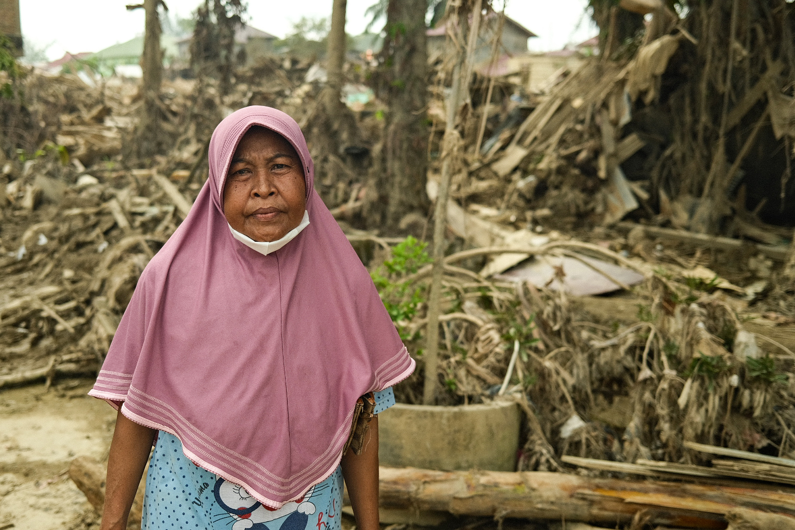 Nuraini said her home, which once belonged to her parents, is destroyed and covered in logs. Her possessions, like her kitchen appliances, are broken and scattered everywhere, and covered in mud. “Our lives are difficult. We are like beggars, asking for help here and there. We have to wait for people to give us rice just so we can eat.”