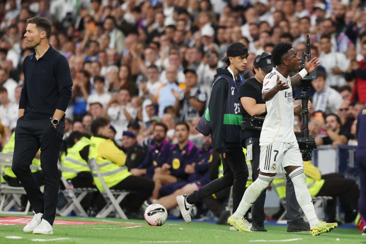 Real Madrid's Brazilian forward #07 Vinicius Junior (R) walks past Real Madrid's Spanish coach Xabi Alonso as he is substituted during the Spanish league football match between Real Madrid CF and FC Barcelona at Santiago Bernabeu Stadium in Madrid on October 26 , 2025. (Photo by Oscar DEL POZO / AFP)