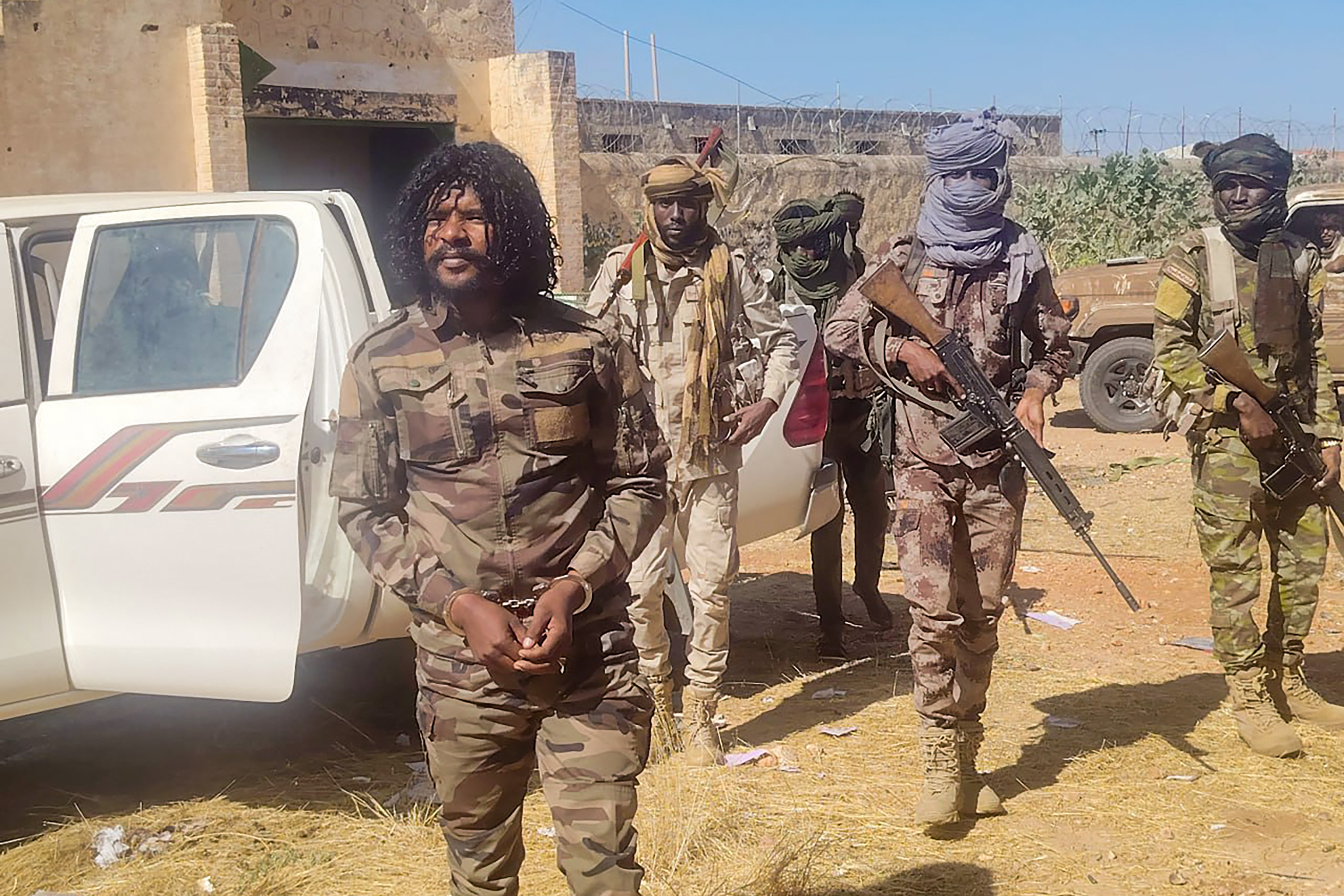 This handout picture released by the Sudanese Rapid Support Forces (RSF) on October 30, 2025, shows RSF members reportedly detaining a fighter known as Abu Lulu (L) in El-Fasher, in war-torn Sudans western Darfur region. In a statement late on October 30, the RSF said it had detained several fighters accused of "violations that occurred during the liberation" of the city, including Lulu who appeared in multiple videos on his TikTok committing summary executions. The RSF, at war with the army since April 2023, seized El-Fasher -- the army's last stronghold in Darfur -- on October 26 after an 18-month siege. (Photo by Rapid Support Forces (RSF) / AFP) / RESTRICTED TO EDITORIAL USE - MANDATORY CREDIT "AFP PHOTO / SUDANESE RAPID SUPPORT FORCES (RSF)" - HANDOUT - NO MARKETING NO ADVERTISING CAMPAIGNS - DISTRIBUTED AS A SERVICE TO CLIENTS