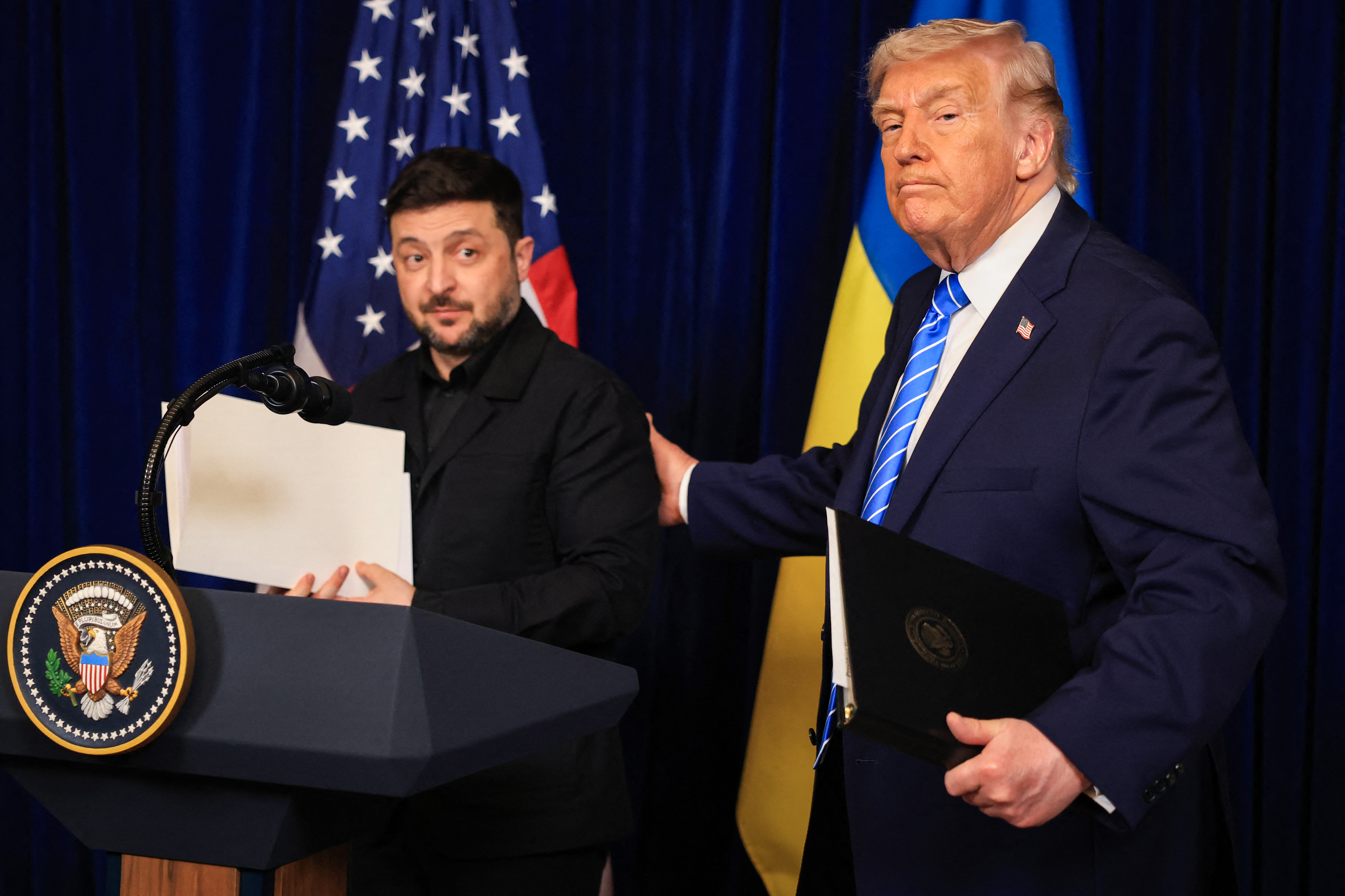 U.S. President Donald Trump and Ukrainian President Volodymyr Zelensky leave a press conference following their meeting at Trump's Mar-a-Lago club