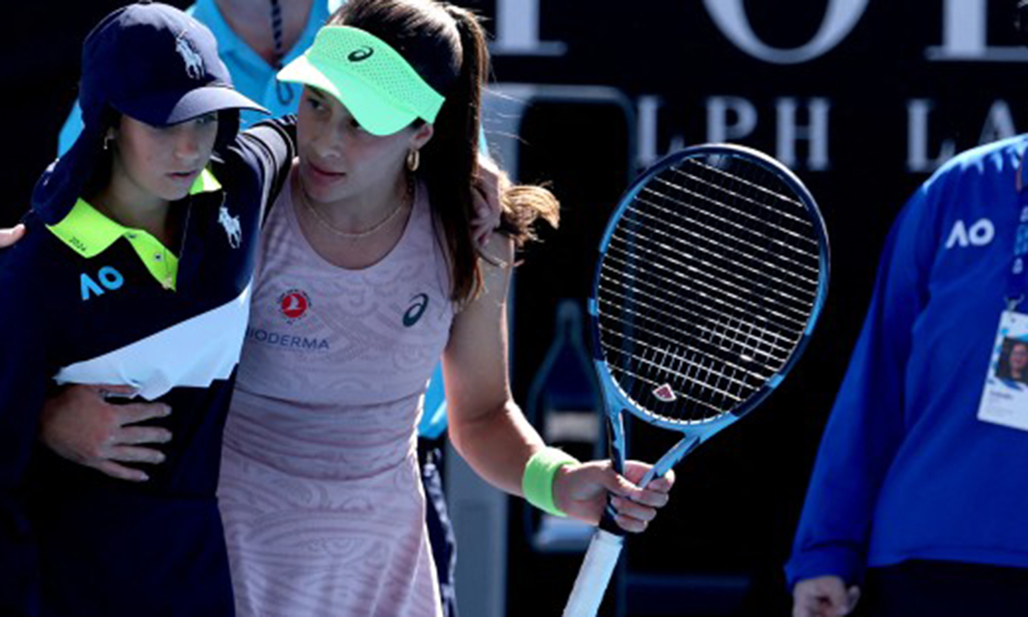 Turkey’s Zeynep Sonmez assists a ball kid after she fainted during Sonmez’s women’s singles match against Russia’s Ekaterina Alexandrova on day one of the Australian Open in Melbourne on January 18, 2026. (Photo by DAVID GRAY / AFP) / -- IMAGE RESTRICTED TO EDITORIAL USE - STRICTLY NO COMMERCIAL USE --