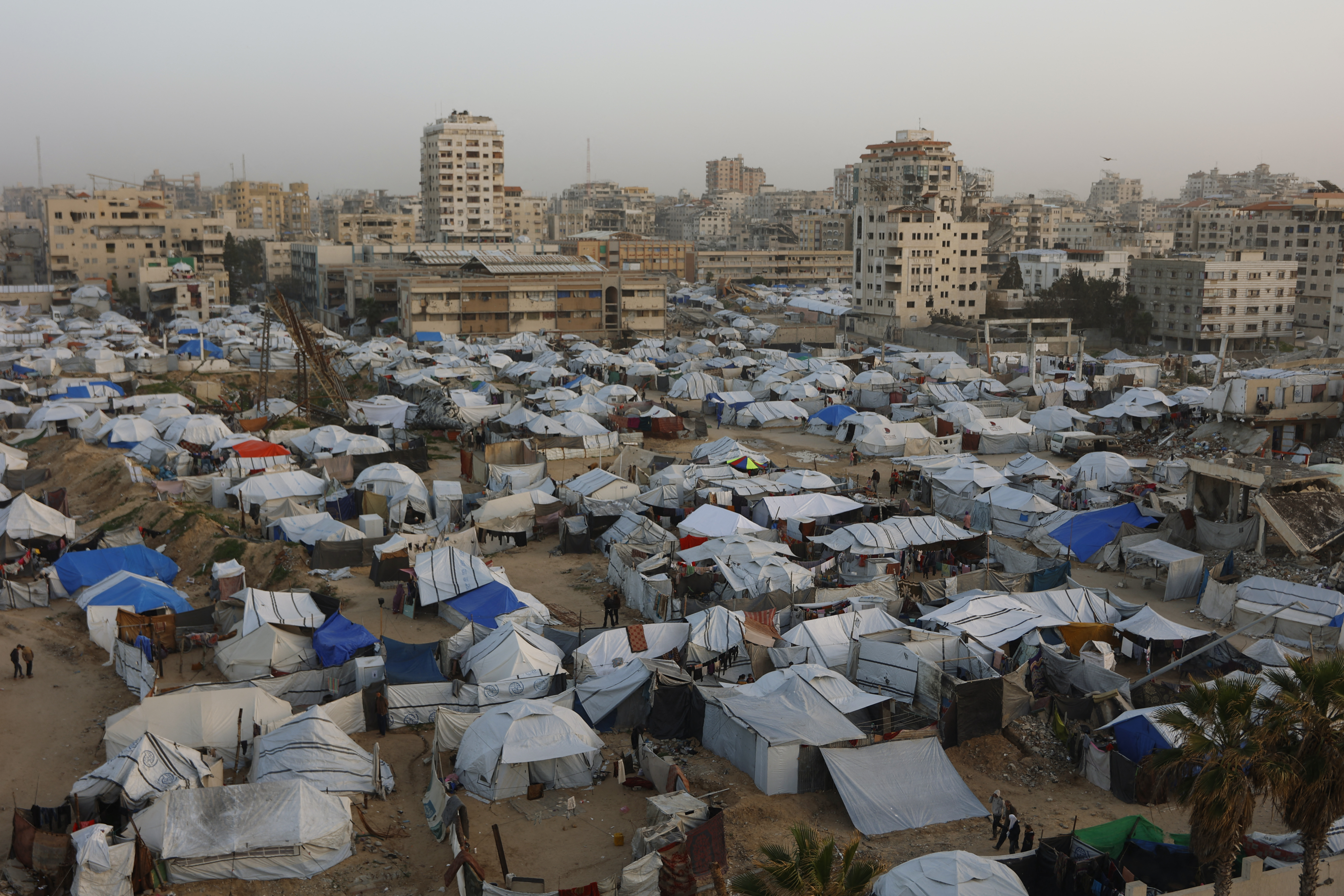 Tents housing displaced Palestinians are erected on empty land