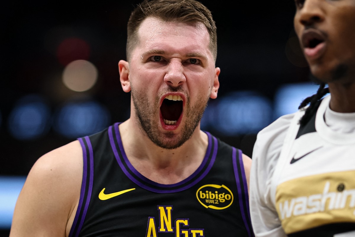 Luka Doncic #77 of the Los Angeles Lakers celebrates in front of Jamir Watkins #5 of the Washington Wizards.