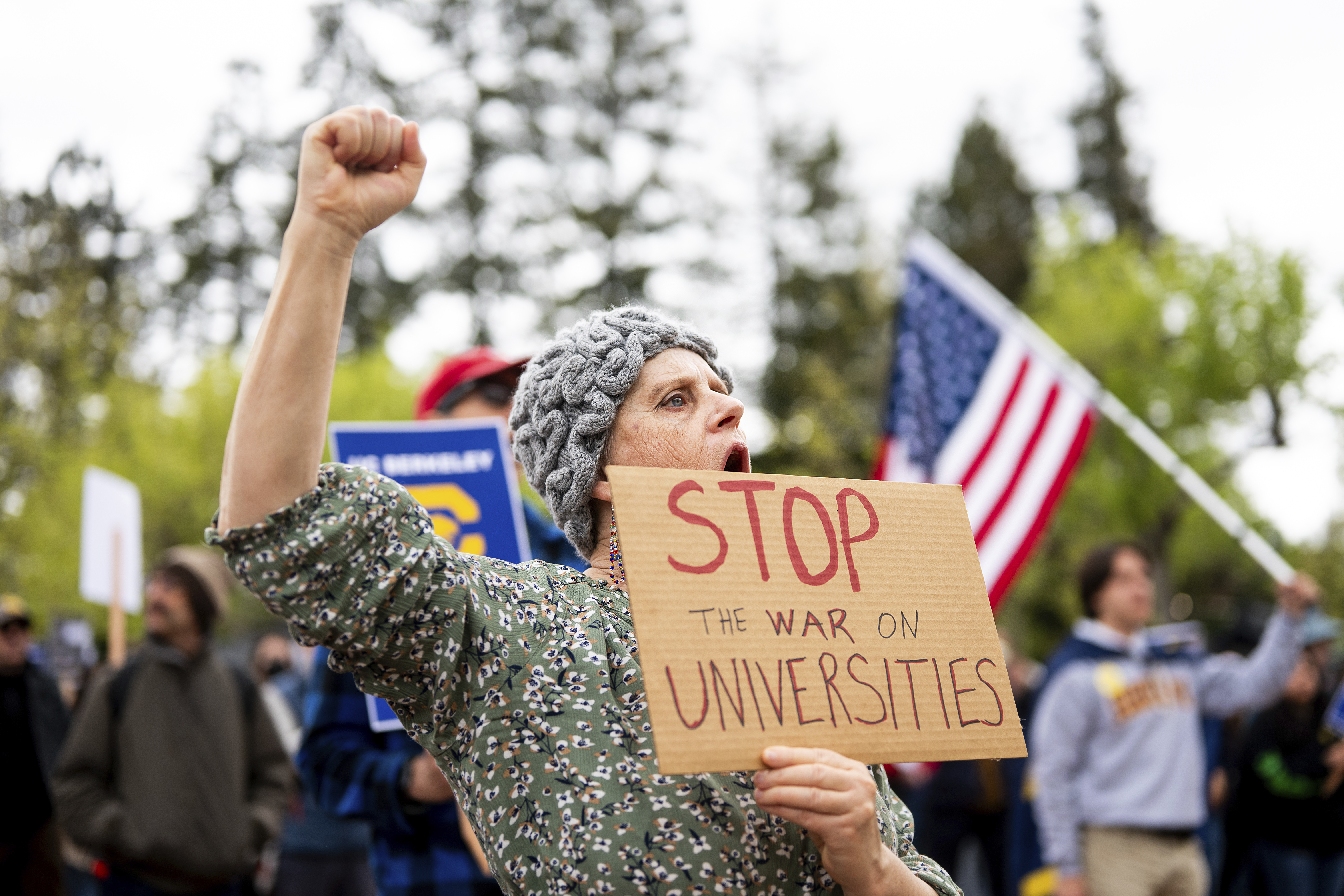 A protester holds up a sign that reads, "Stop the war on universities"
