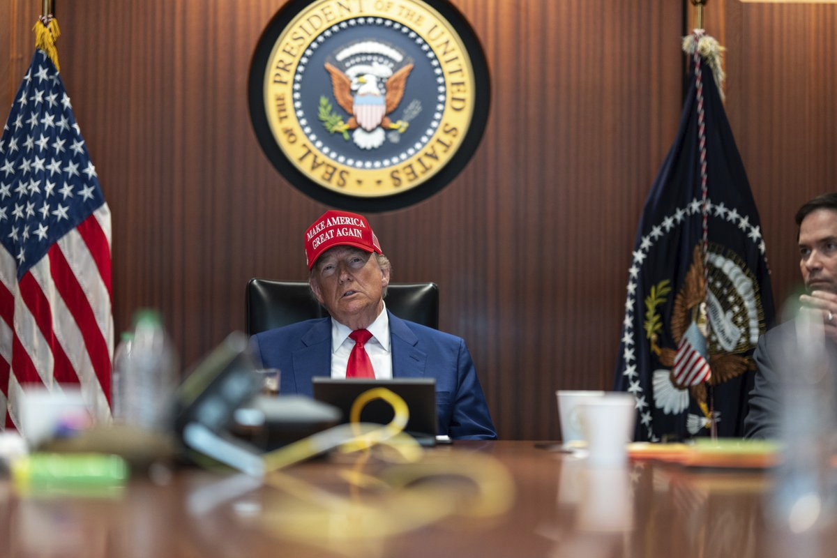 Trump sits in a red cap in the White House situation room