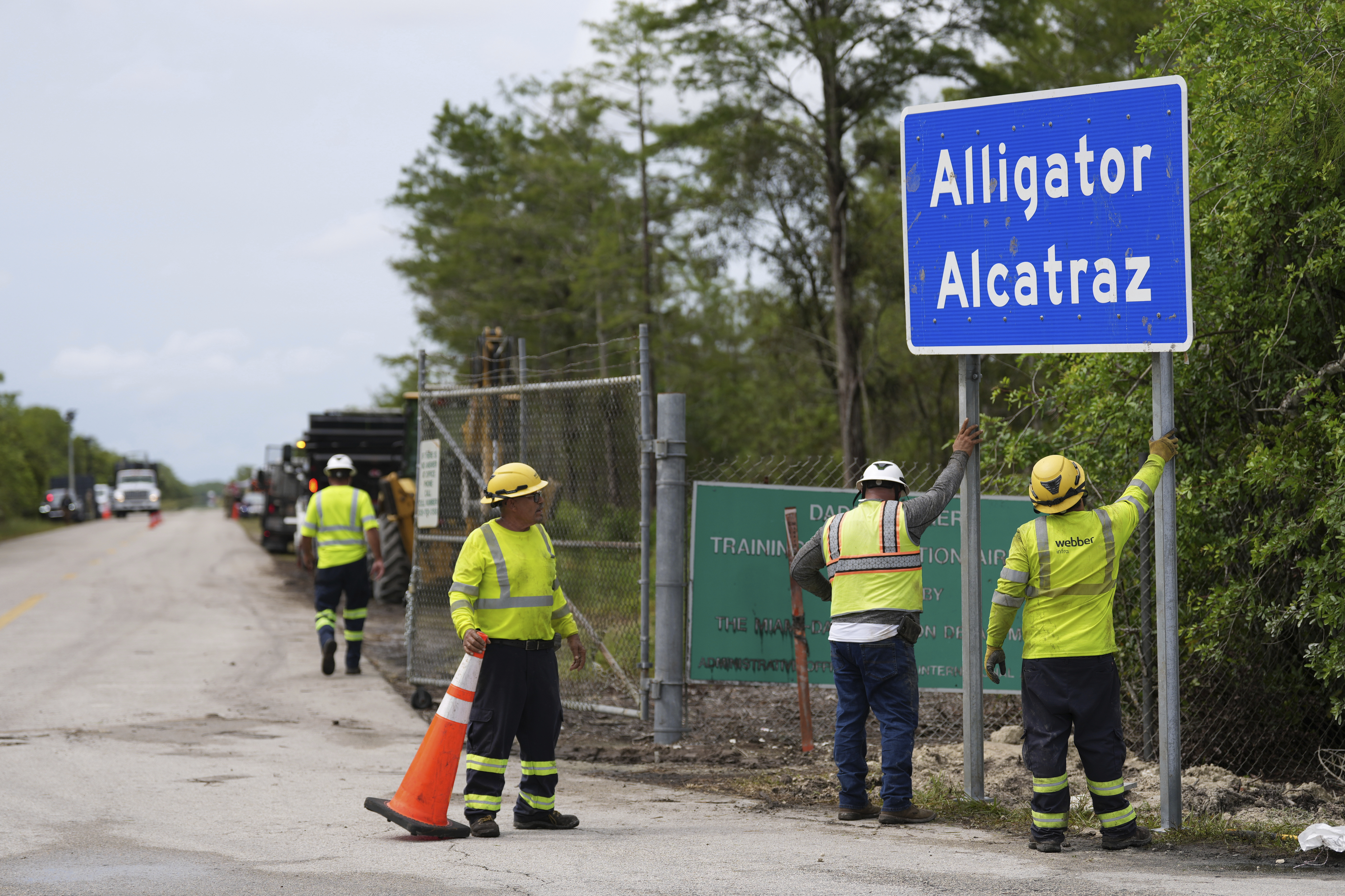 Construction crews erect an "Alligator Alcatraz" sign