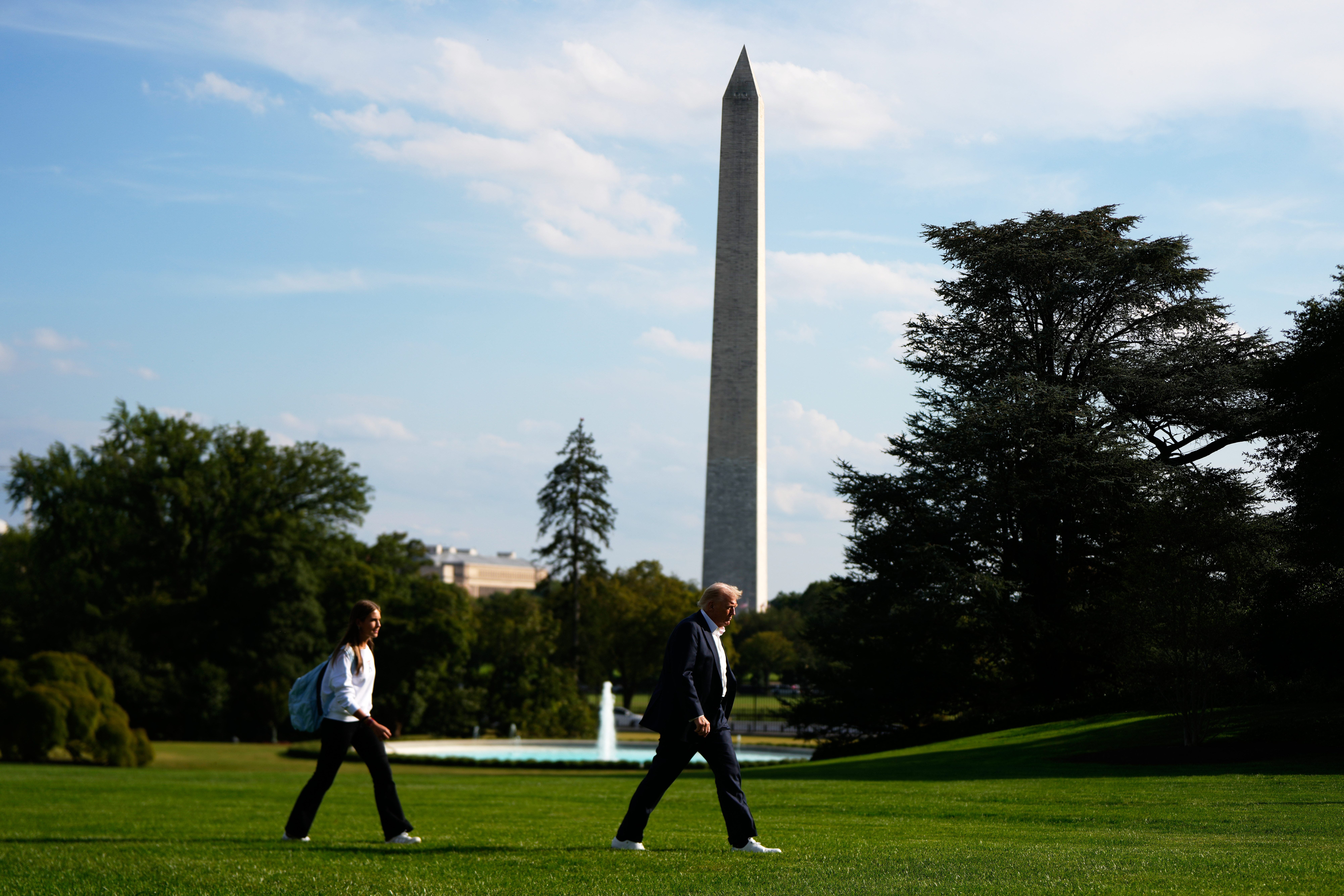 Trump and Kai Trump walk across the White House lawn.