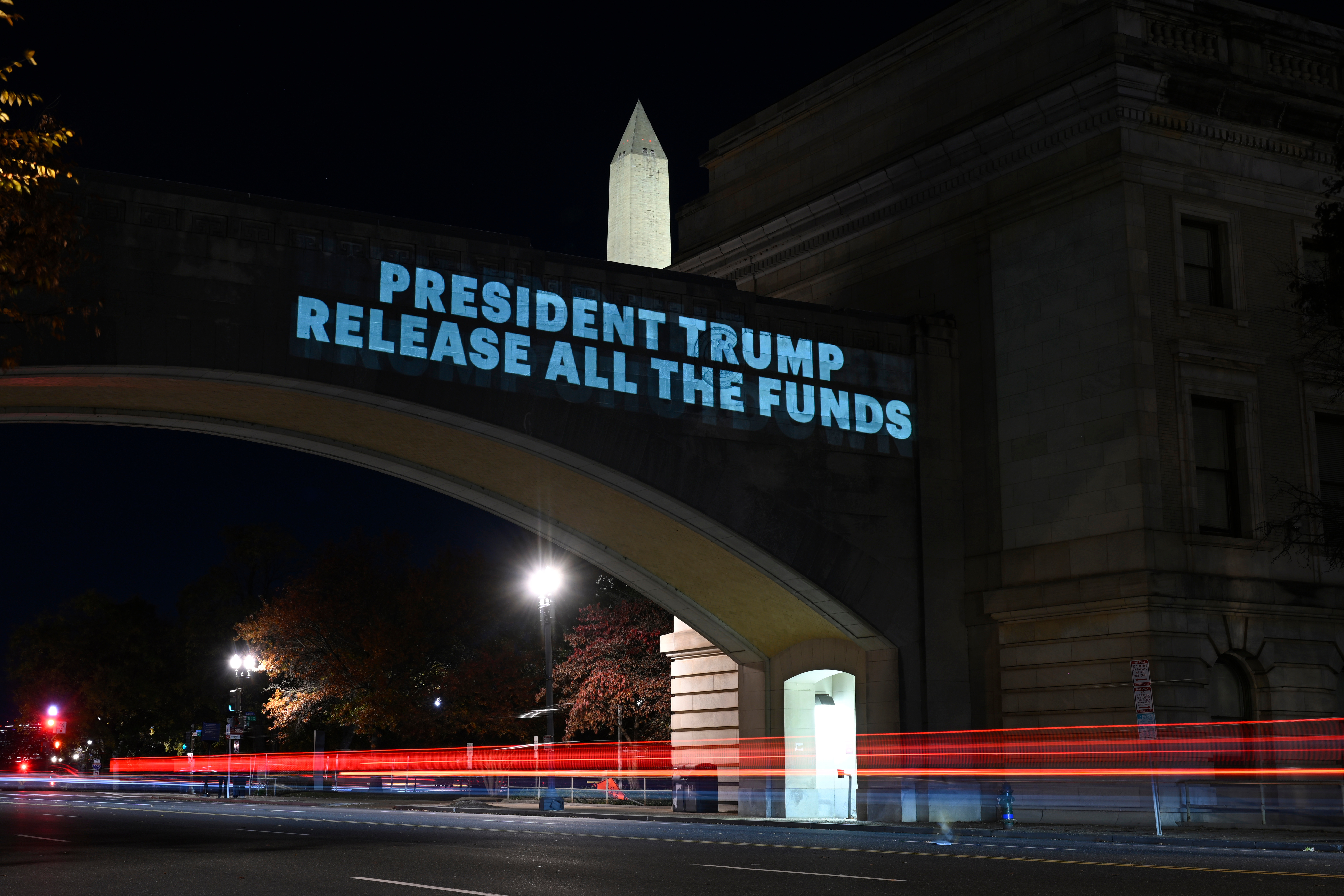 Protesters flash a sign on a bridge in Washington, DC, to protest cuts to SNAP