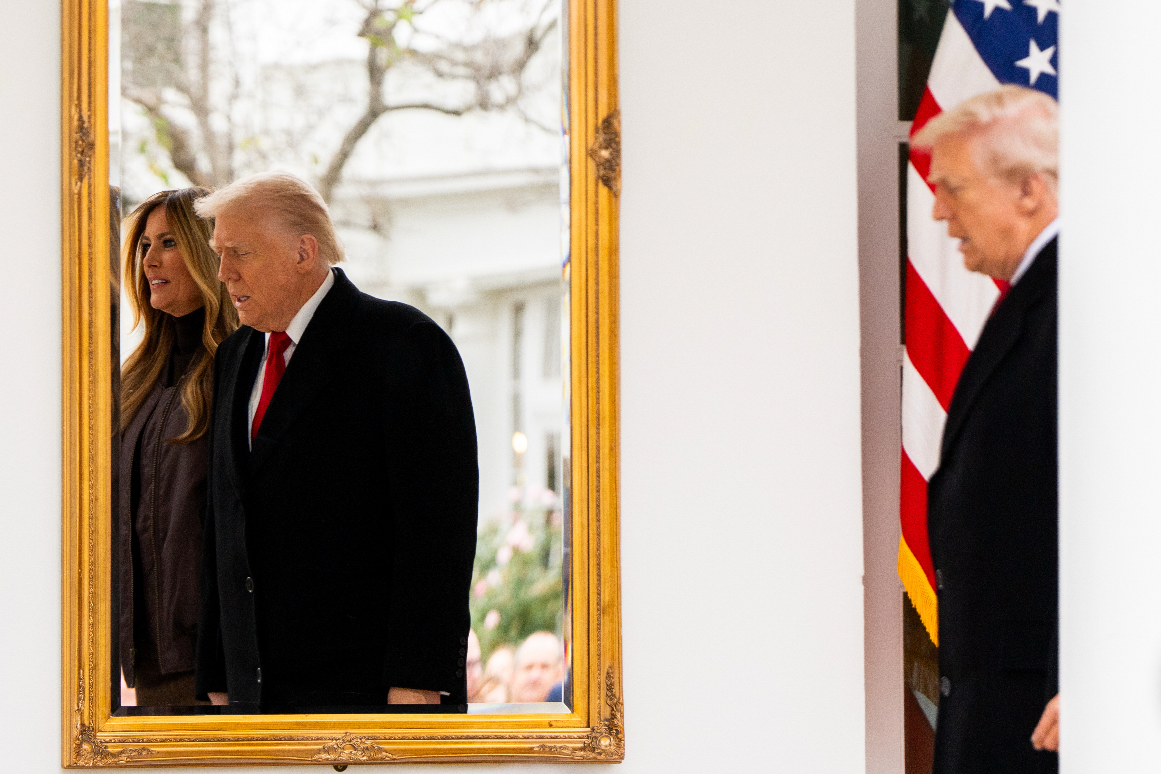 Donald Trump and Melania Trump pass a mirror at the White House