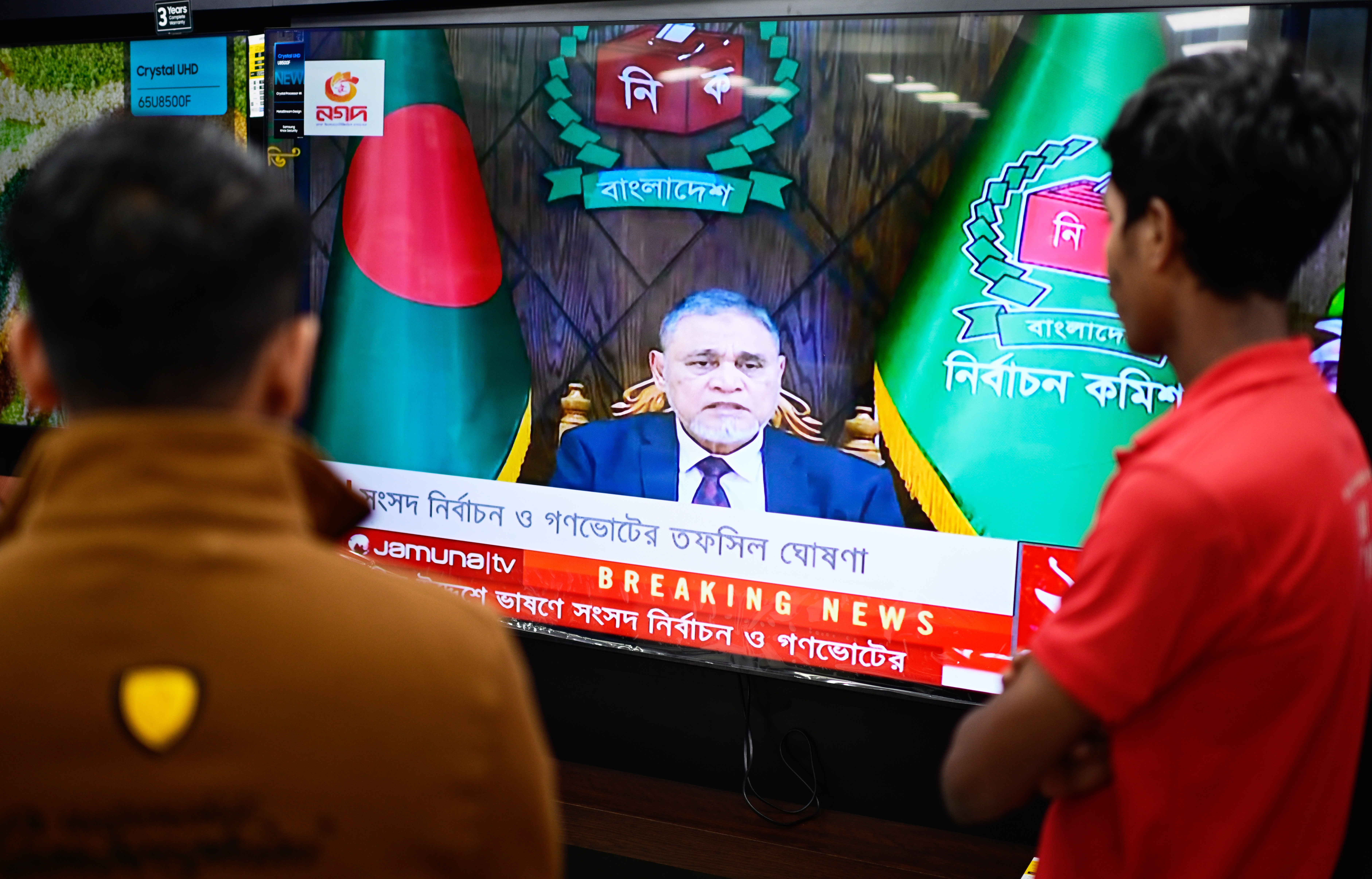 People watch Bangladesh's Chief Election Commissioner AMM Nasir Uddin's address to the nation on a TV, in Dhaka
