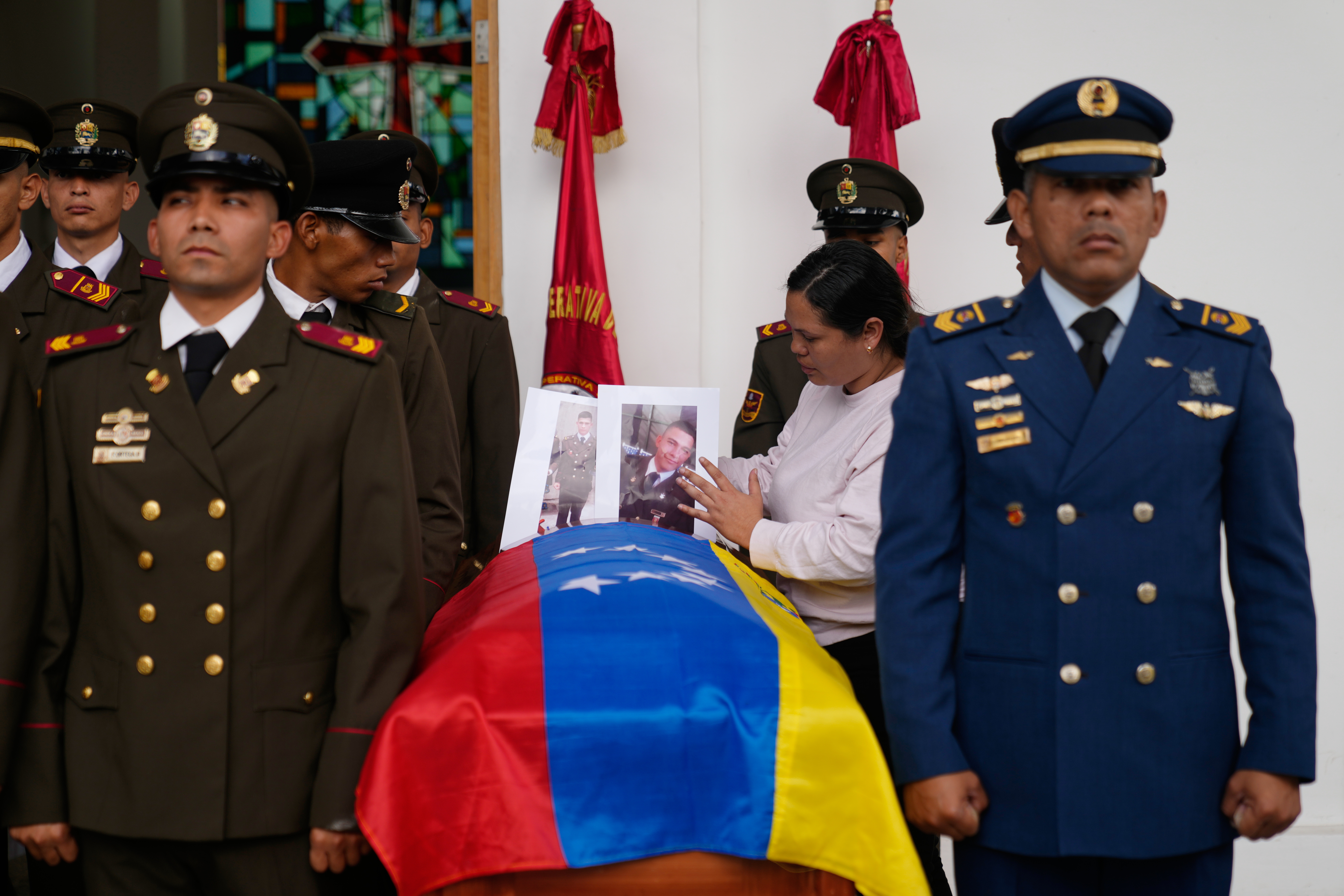 Two soldiers flank a coffin draped with the Venezuelan flag