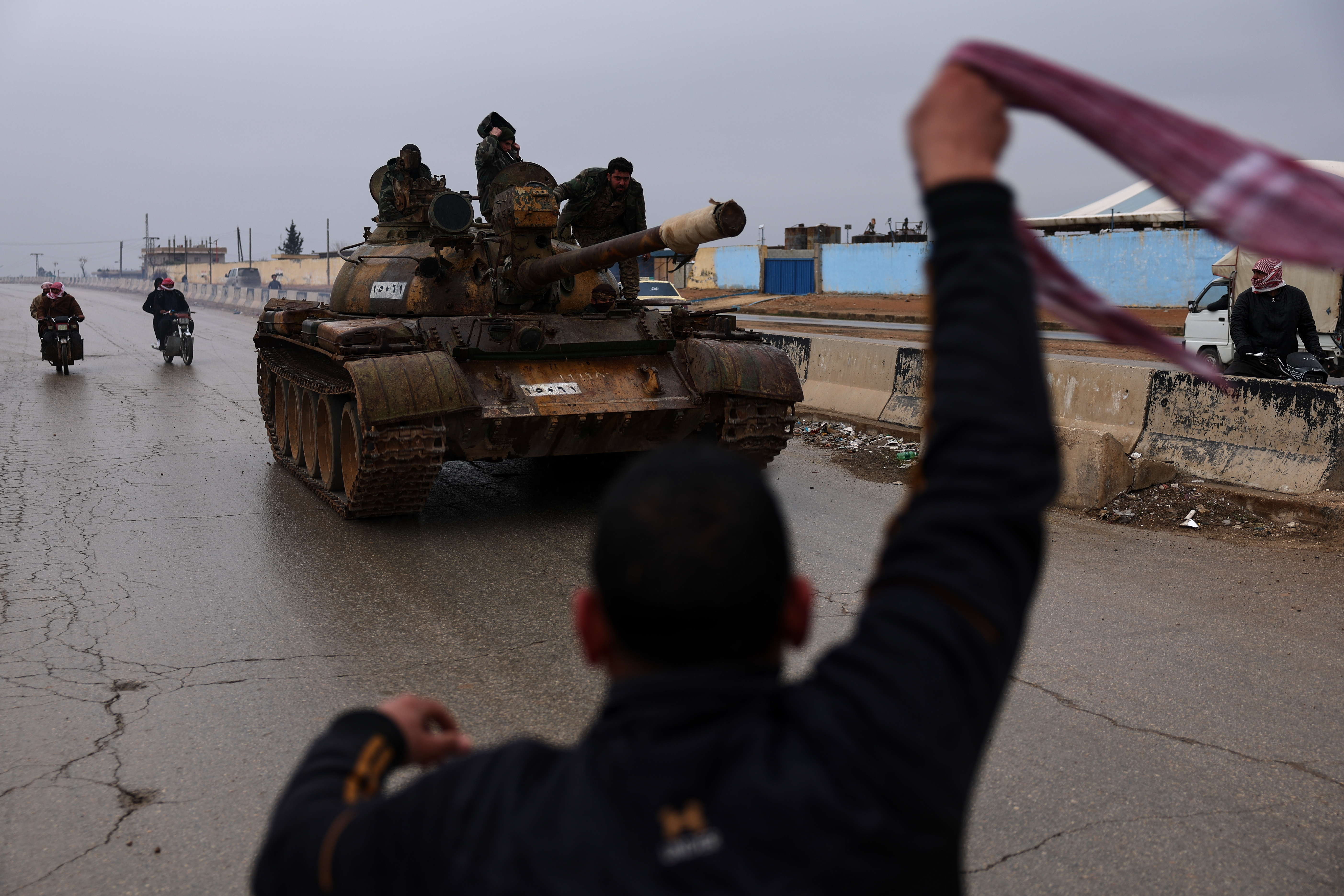 People welcome Syrian government forces as they enter the town of Deir Hafer, Syria