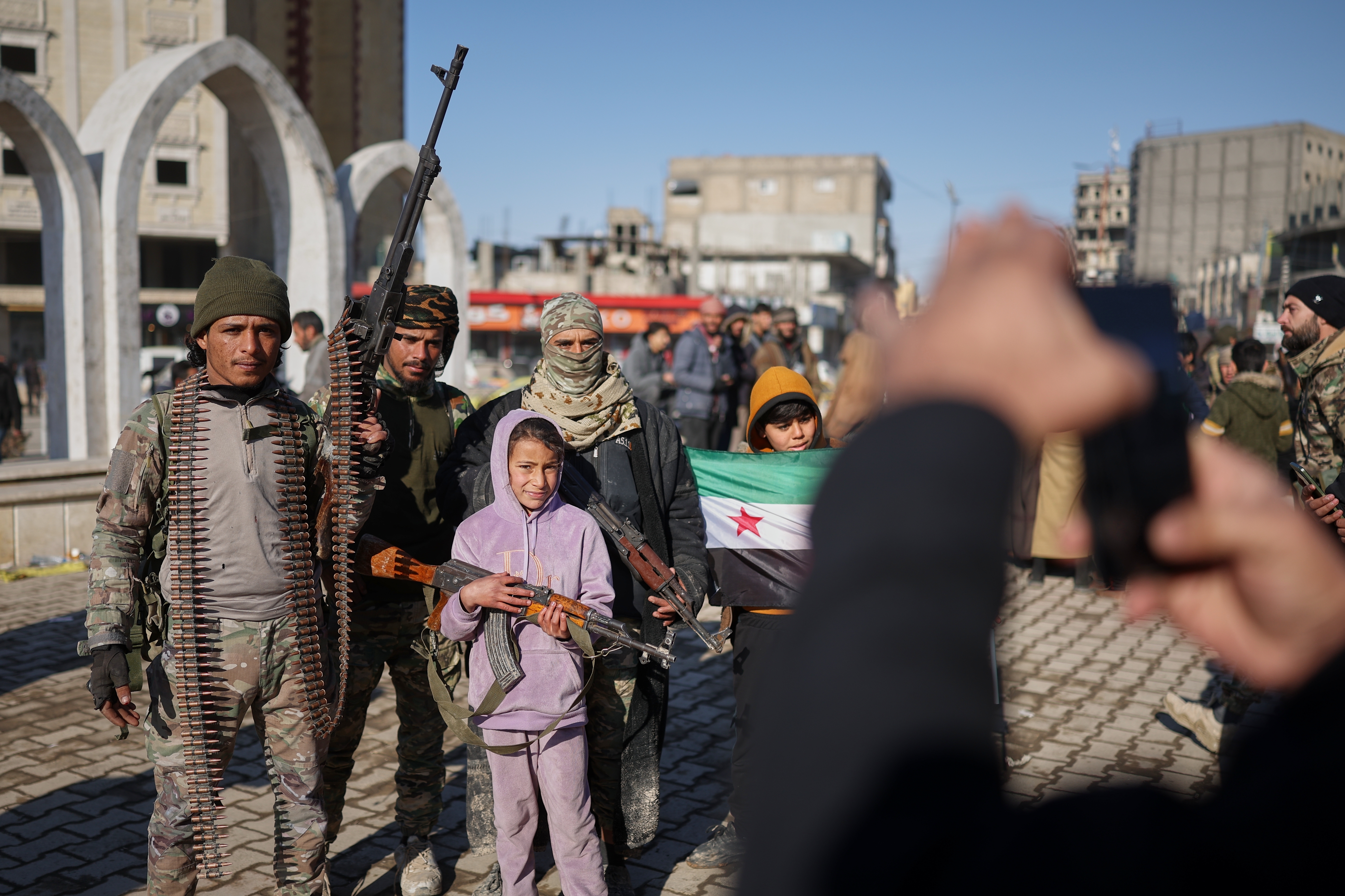 Tribal fighters with local children after Syrian government troops took control of Raqqa from the Syrian Democratic Forces