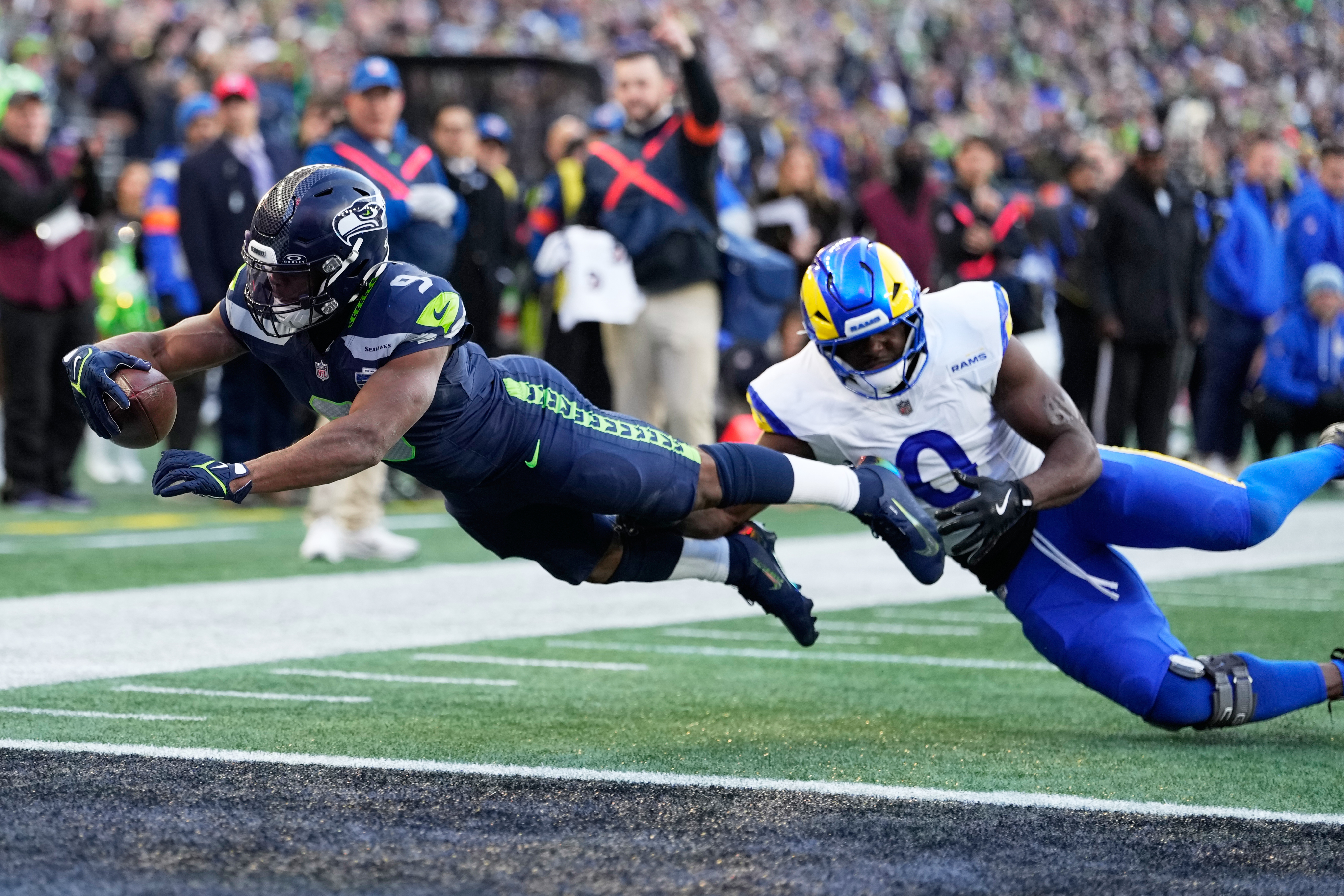 Seattle Seahawks running back Kenneth Walker III (9) scores a touchdown past Los Angeles Rams linebacker Byron Young (0) during the first half of the NFC Championship NFL football game