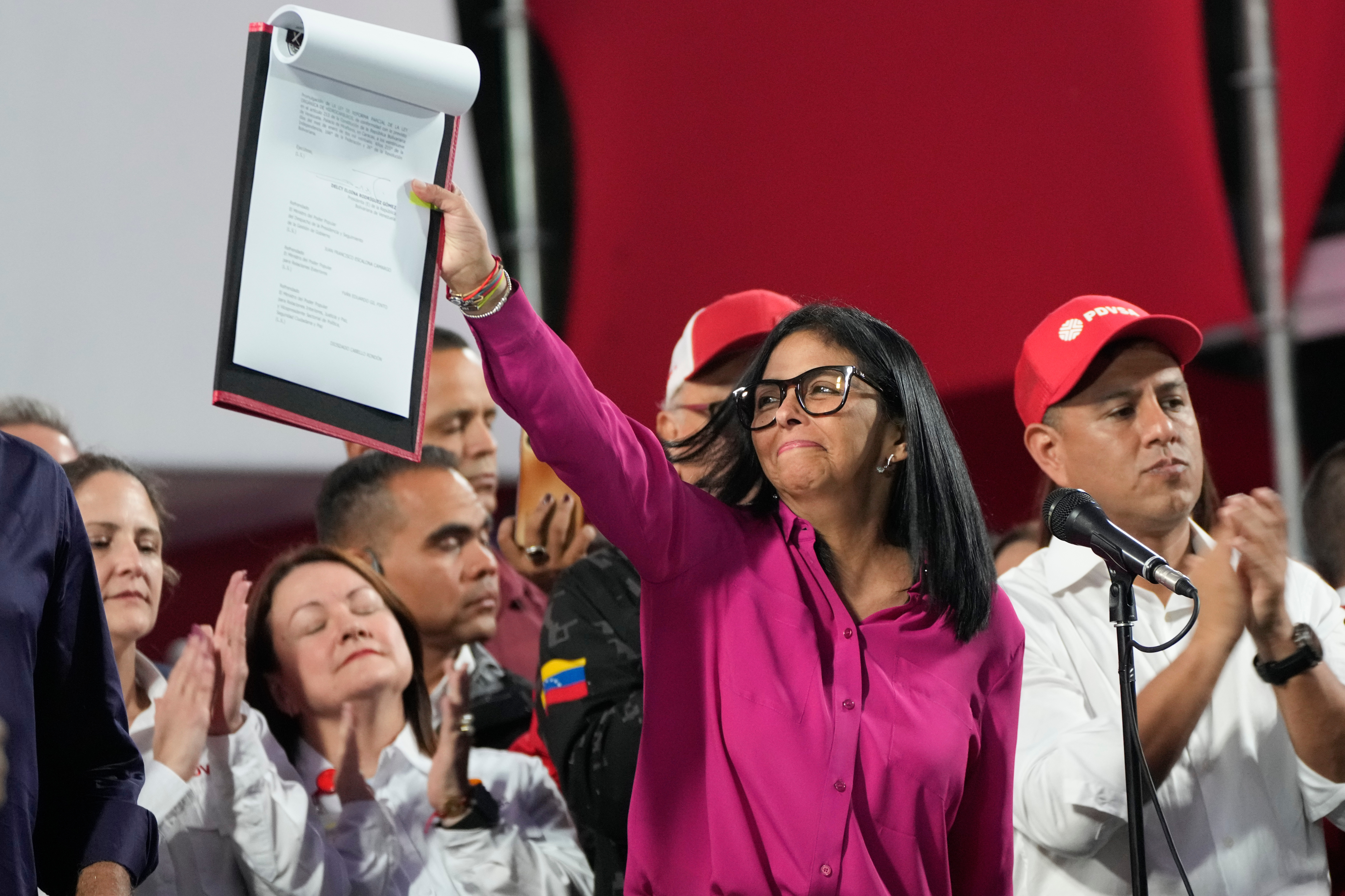Venezuela's Delcy Rodriguez raises a document in a signing ceremony