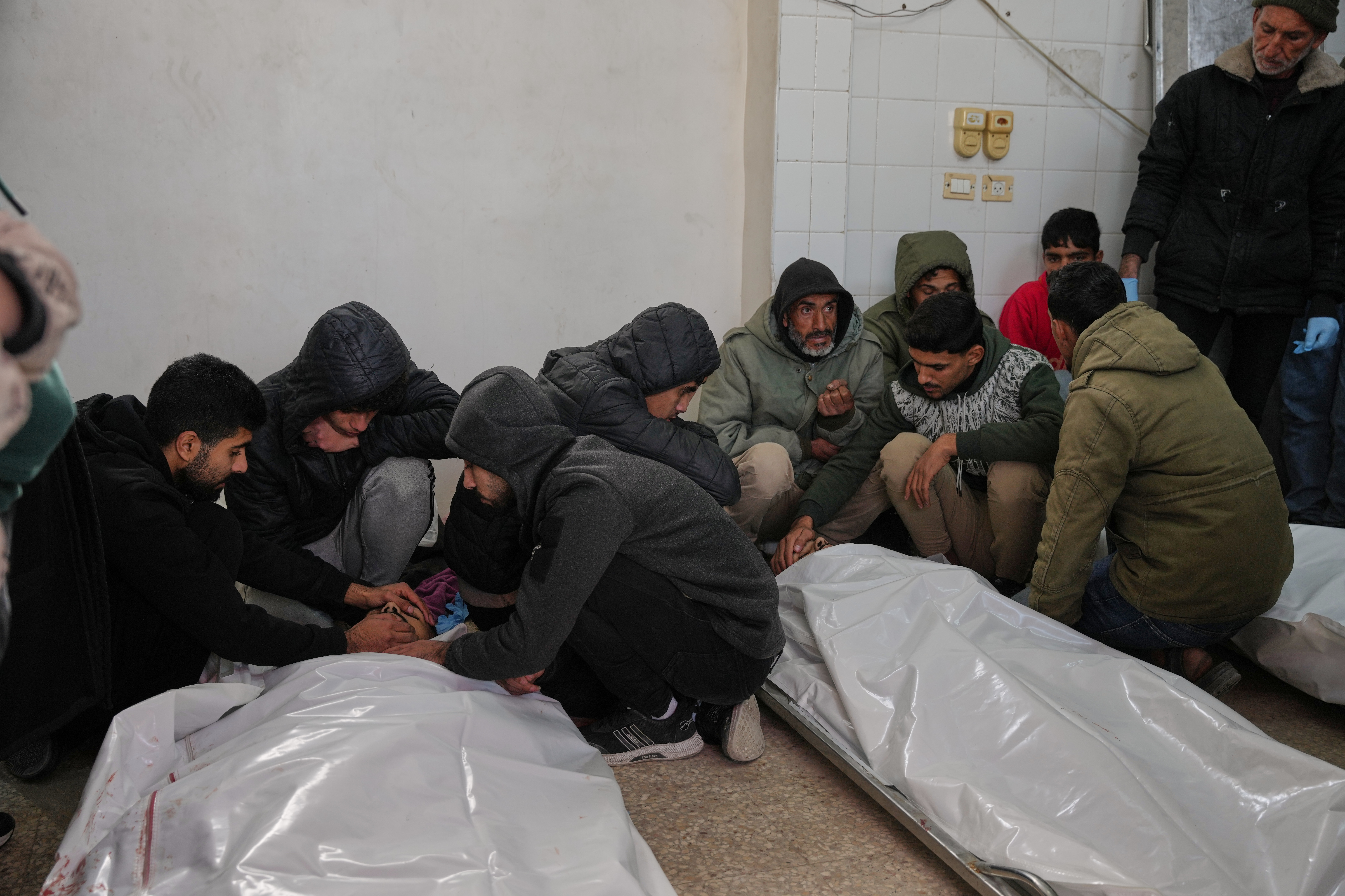 Palestinians mourn over the bodies of people who were killed in an Israeli strike, before their funeral at Al-Aqsa Hospital in Deir al-Balah, central Gaza Strip, Friday, Jan. 30, 2026. (AP Photo/Abdel Kareem Hana)