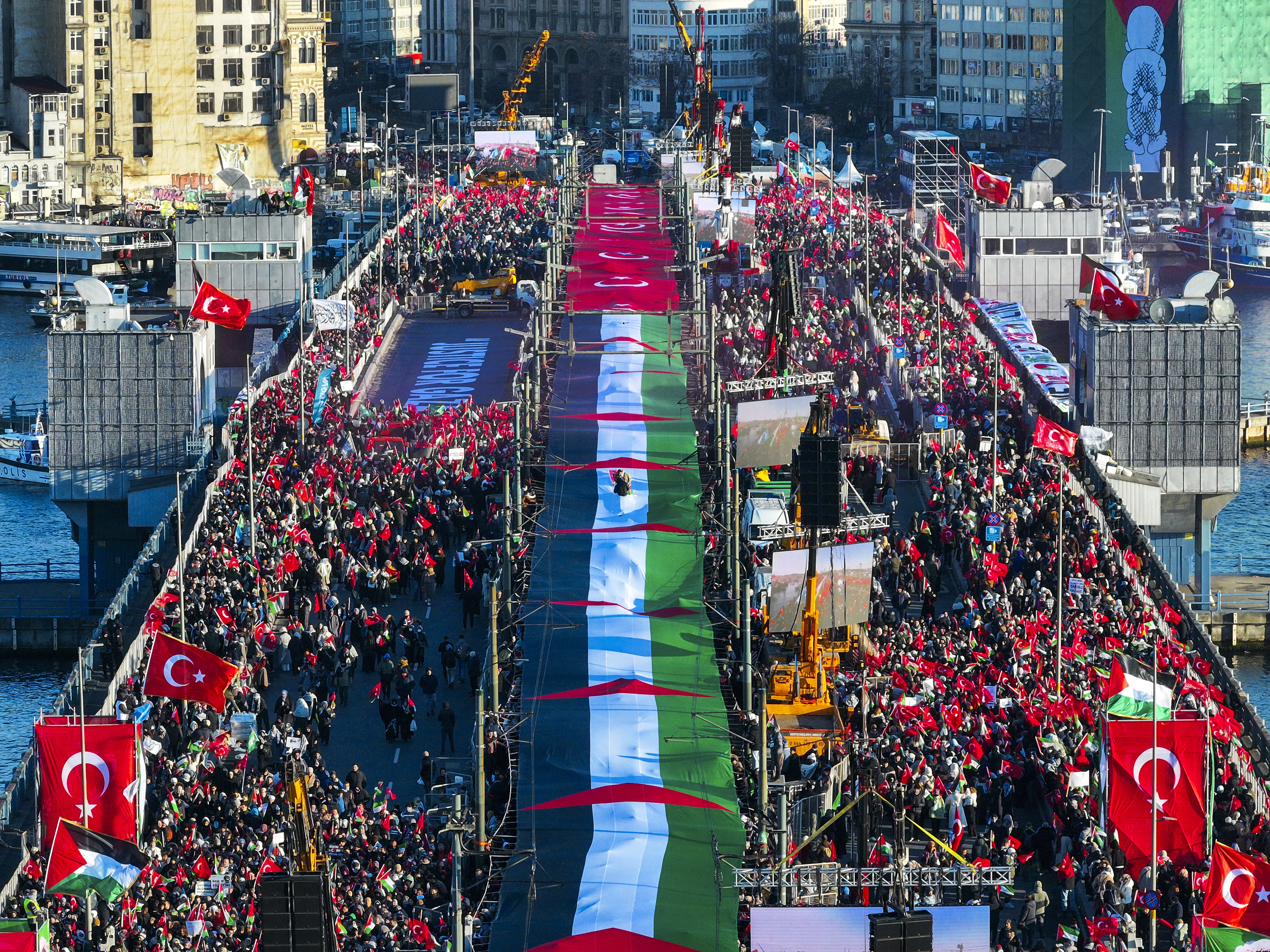 ISTANBUL, TURKIYE - JANUARY 1: An aerial view of boats carrying Palestinian flags around Galata Bridge as thousands of people have gathered across Istanbul to march in solidarity with Palestinians, calling for an end to war on Gaza, on January 1, 2026. The 'We Do Not Remain Silent, We Do Not Forget Palestine' rally, organised by the Humanitarian Alliance and the National Will Platform, brought together more than 400 civil society organisations. (Photo by Muhammed Enes Yildirim/Anadolu via Getty Images)